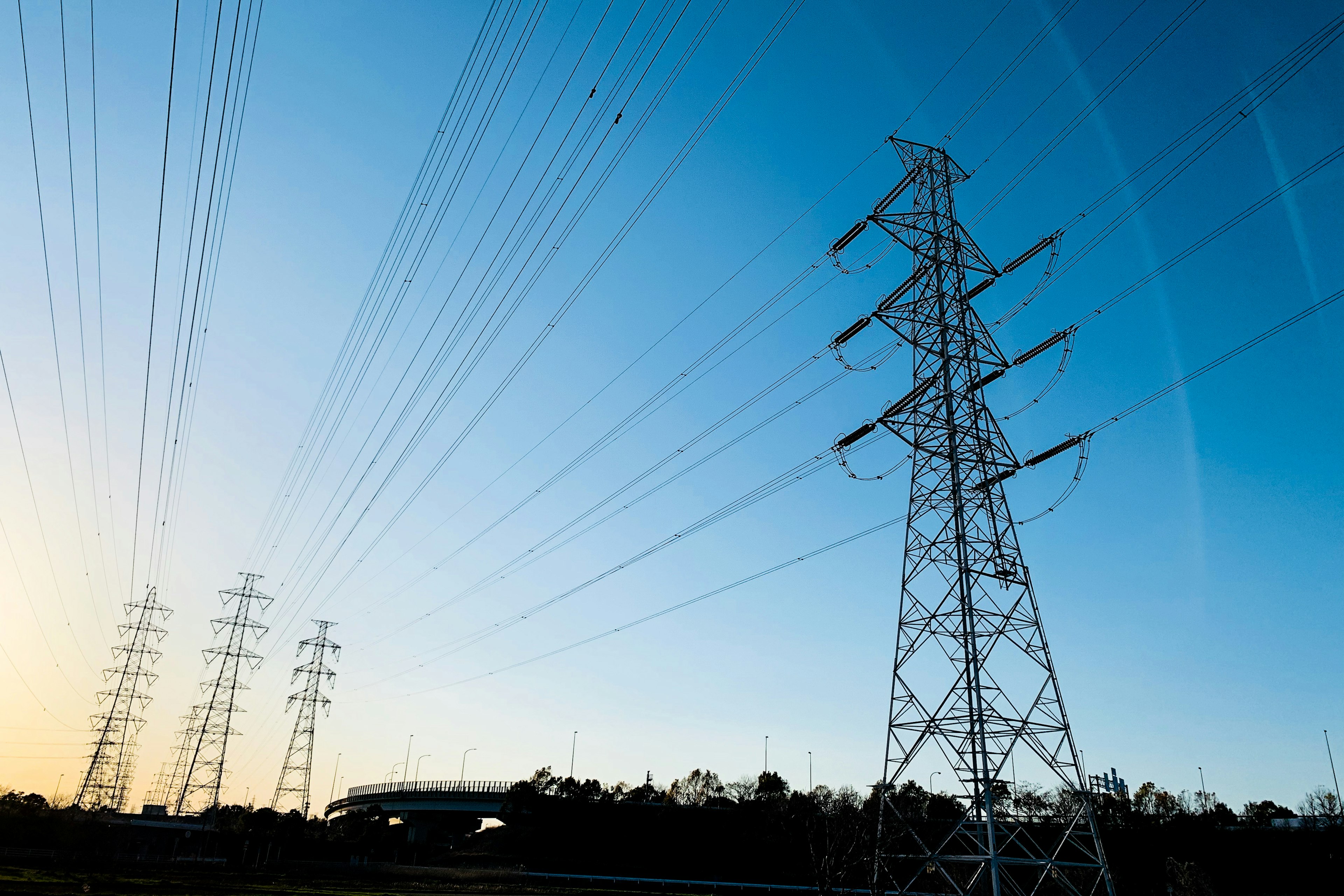 Líneas eléctricas contra un cielo azul durante el atardecer