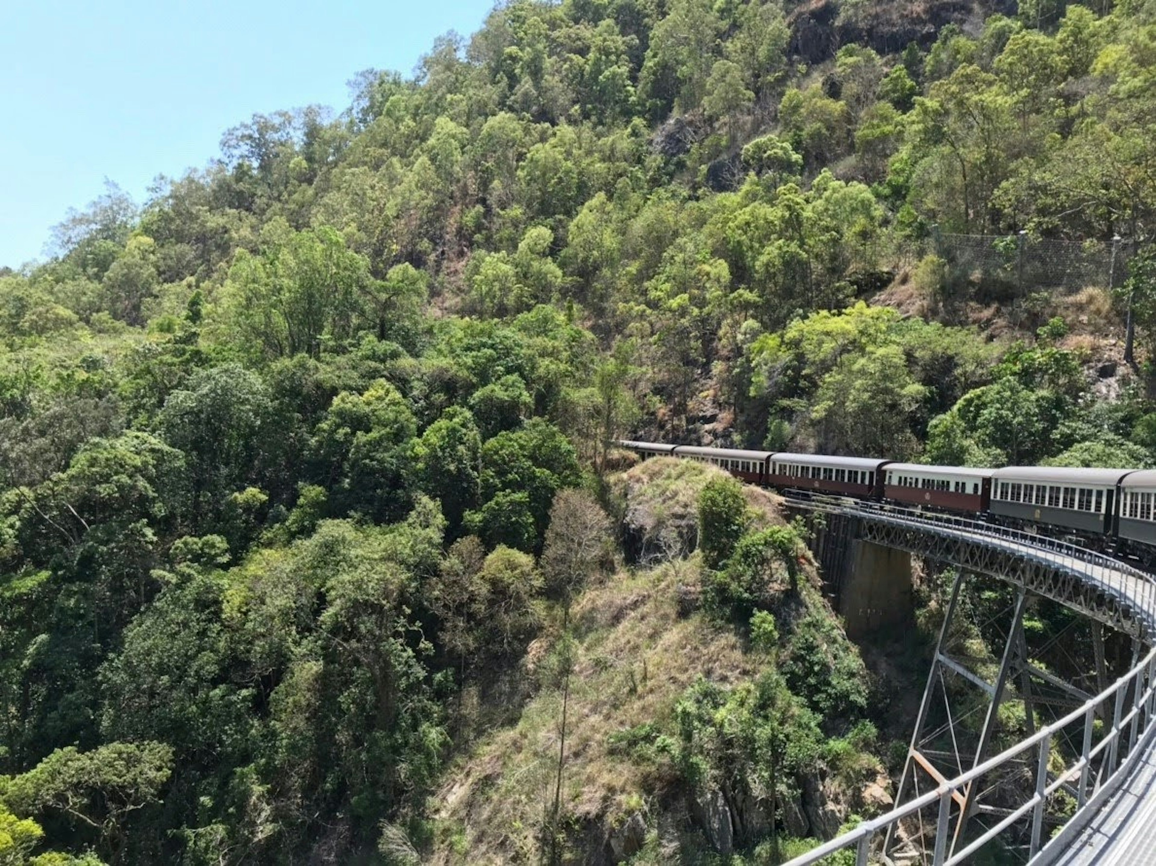 Una ferrovia tortuosa con montagne verdeggianti sullo sfondo