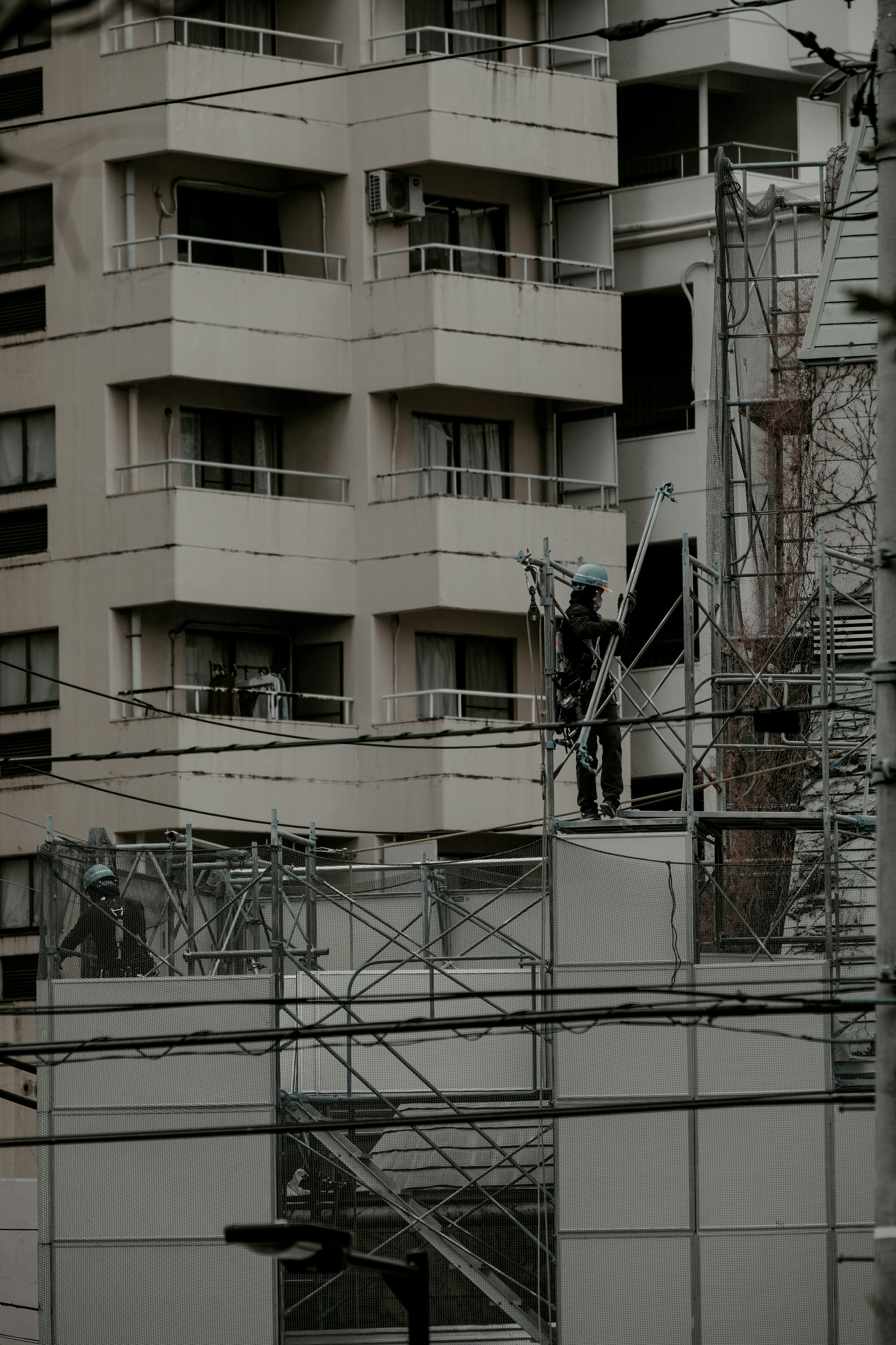 ทัศนียภาพในเมืองที่มีคนงานอยู่บน scaffolding กับด้านหน้าของอาคาร