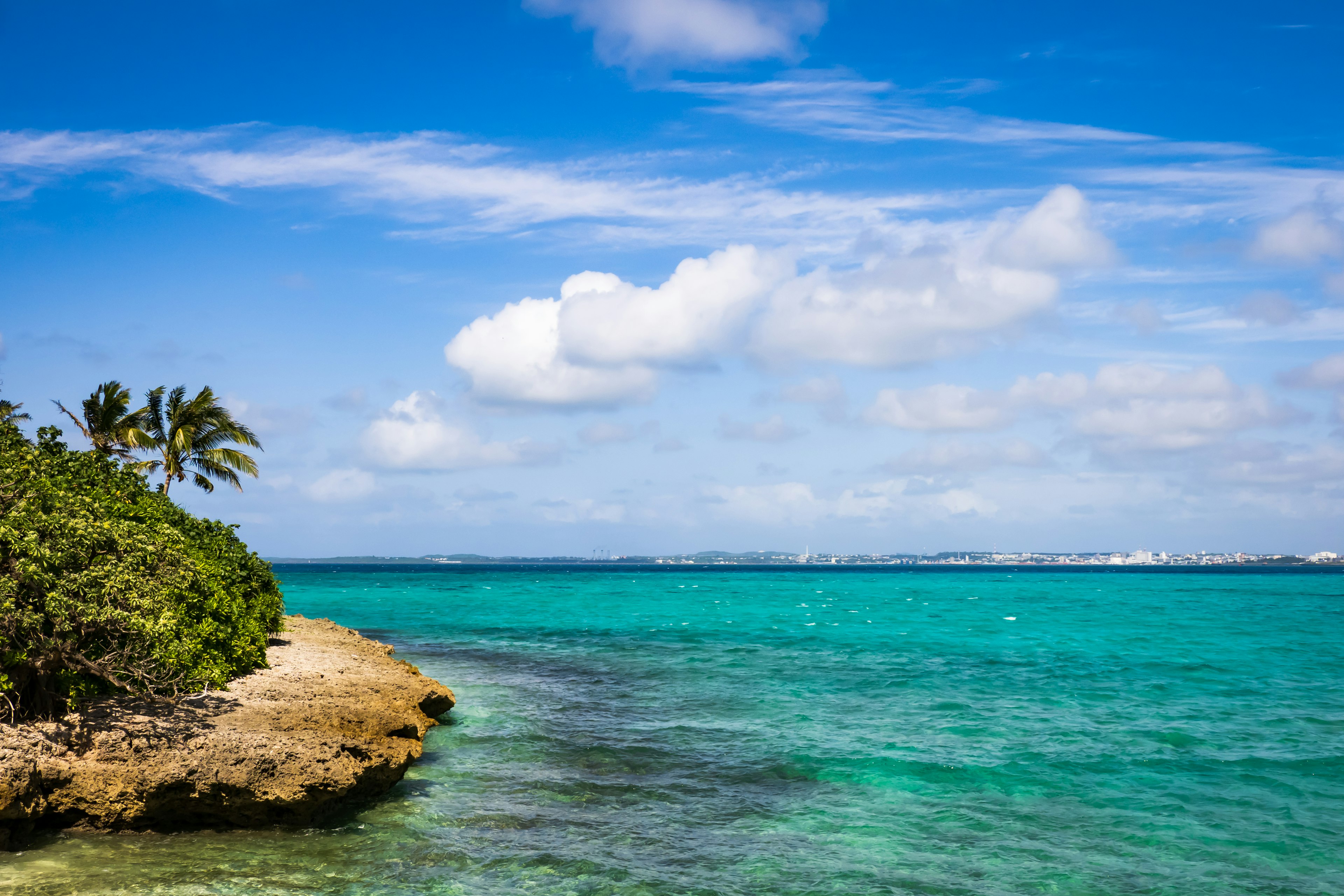 Belle côte sous la mer bleue et les nuages blancs