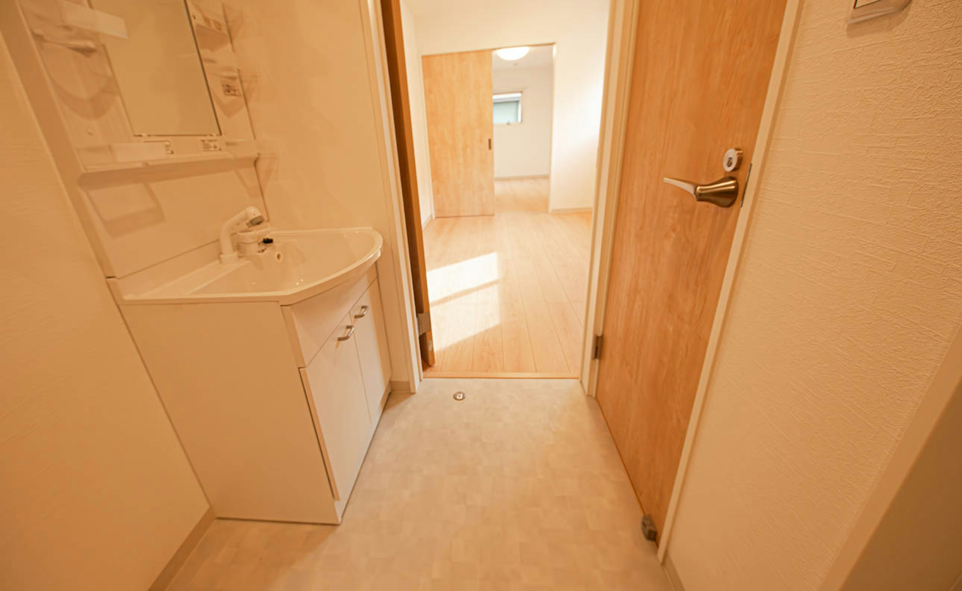 Brightly lit bathroom with a door leading to another room