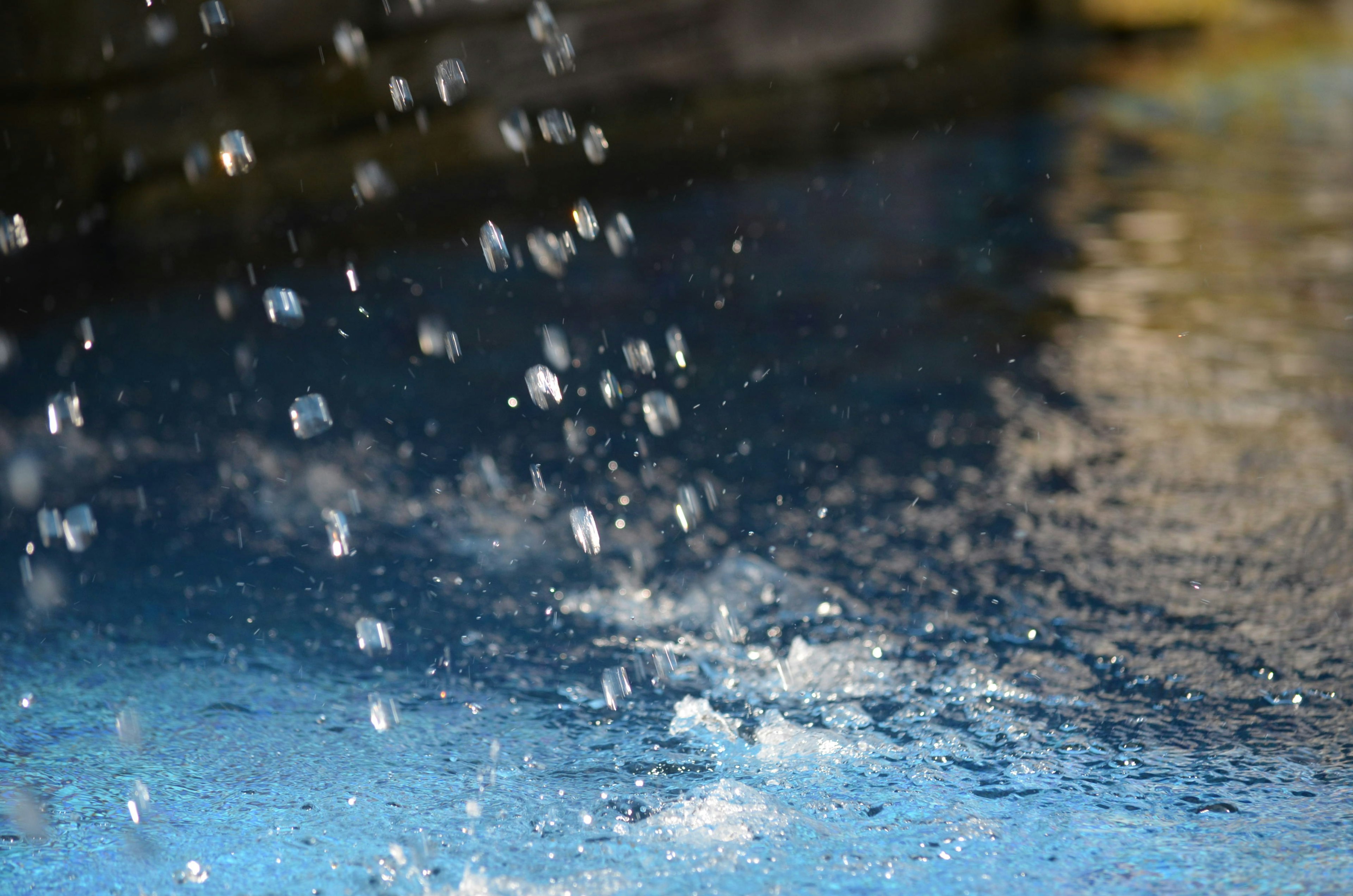 Wassertropfen spritzen auf eine blaue Oberfläche