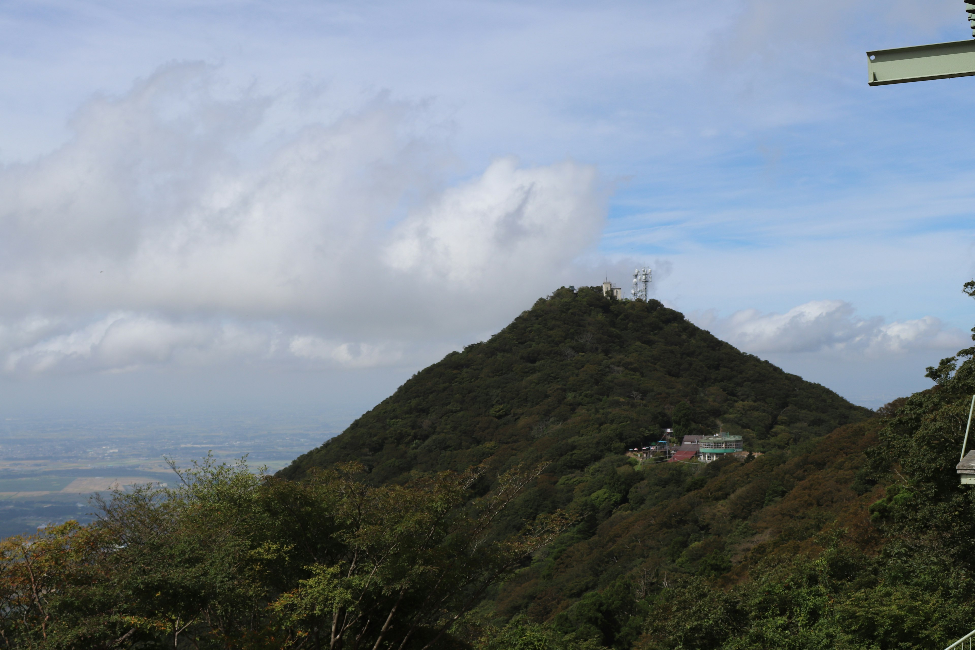 Green hill landscape under a blue sky with clouds