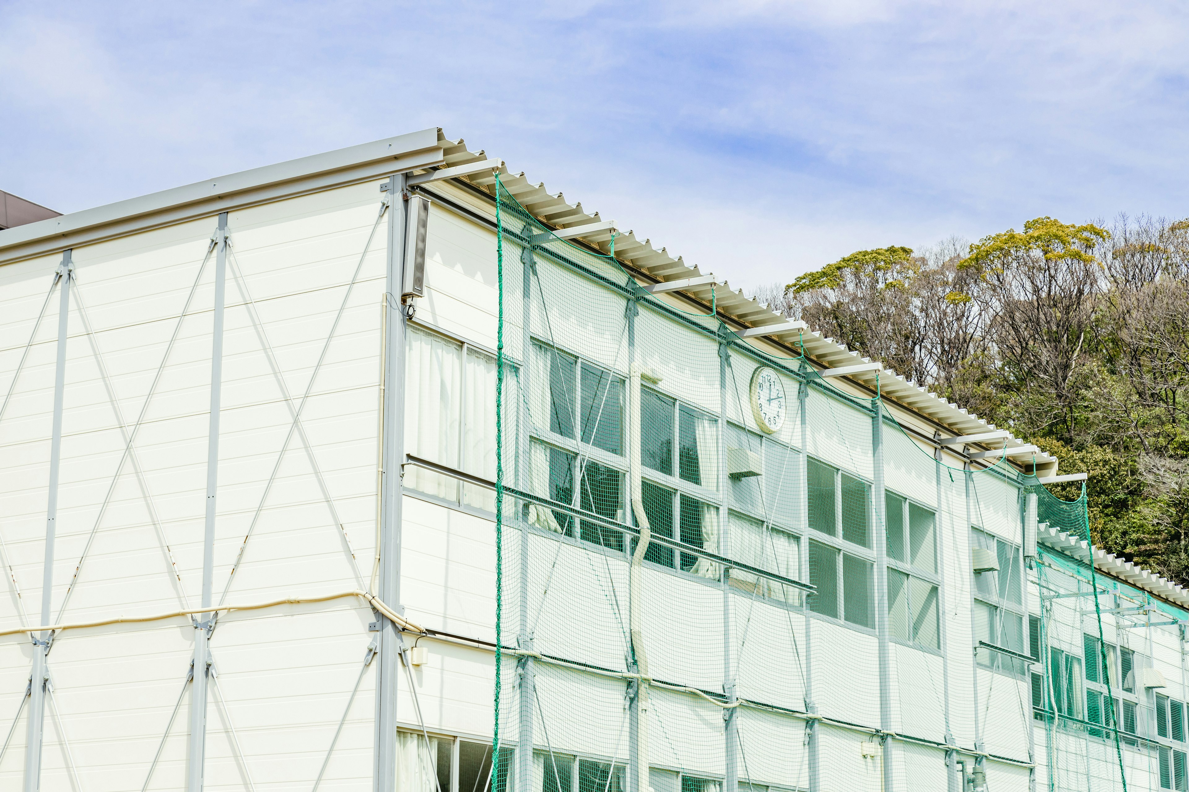 Construction site featuring a building with green scaffolding and large windows