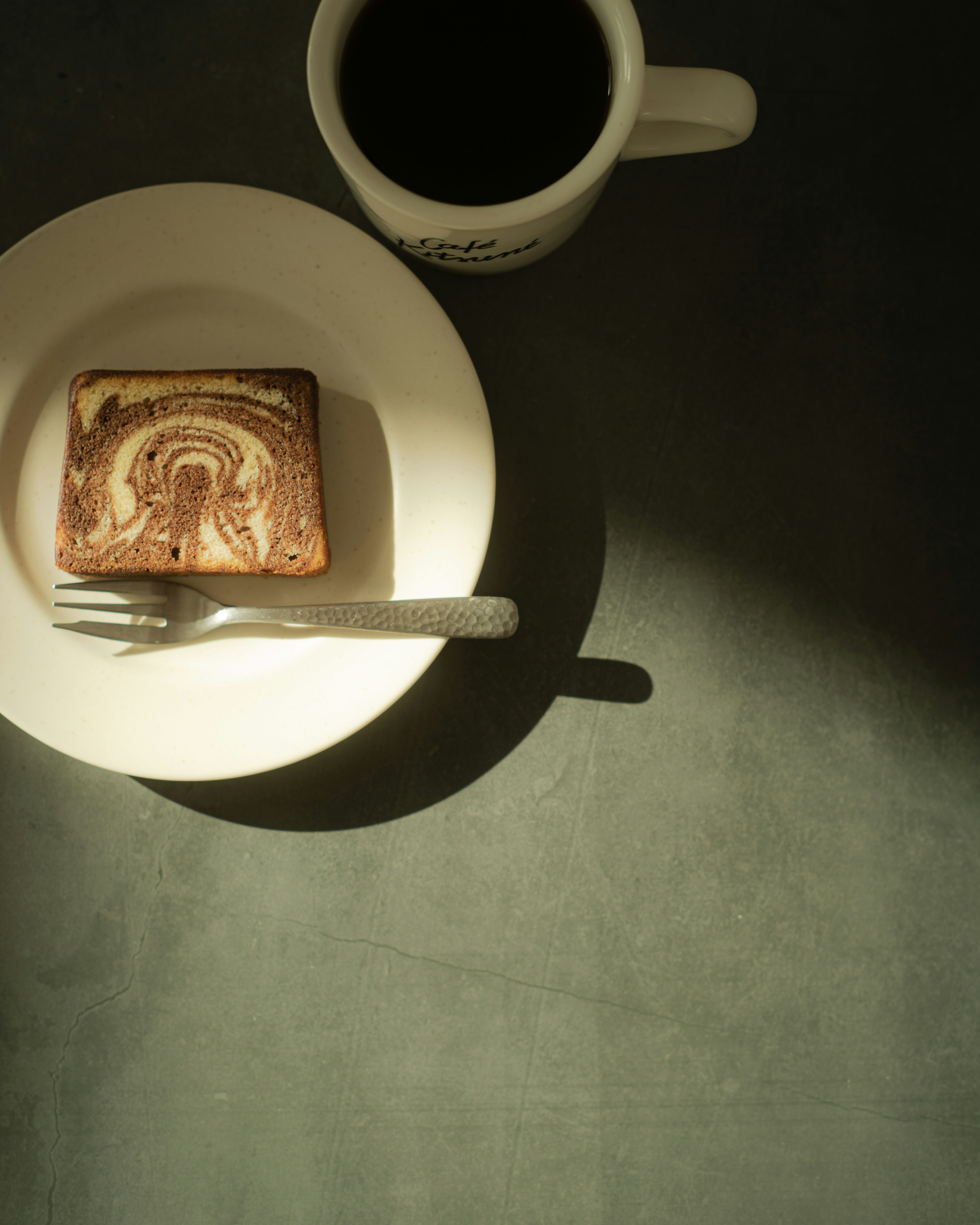 Un dessert su un piatto con una tazza di caffè accanto