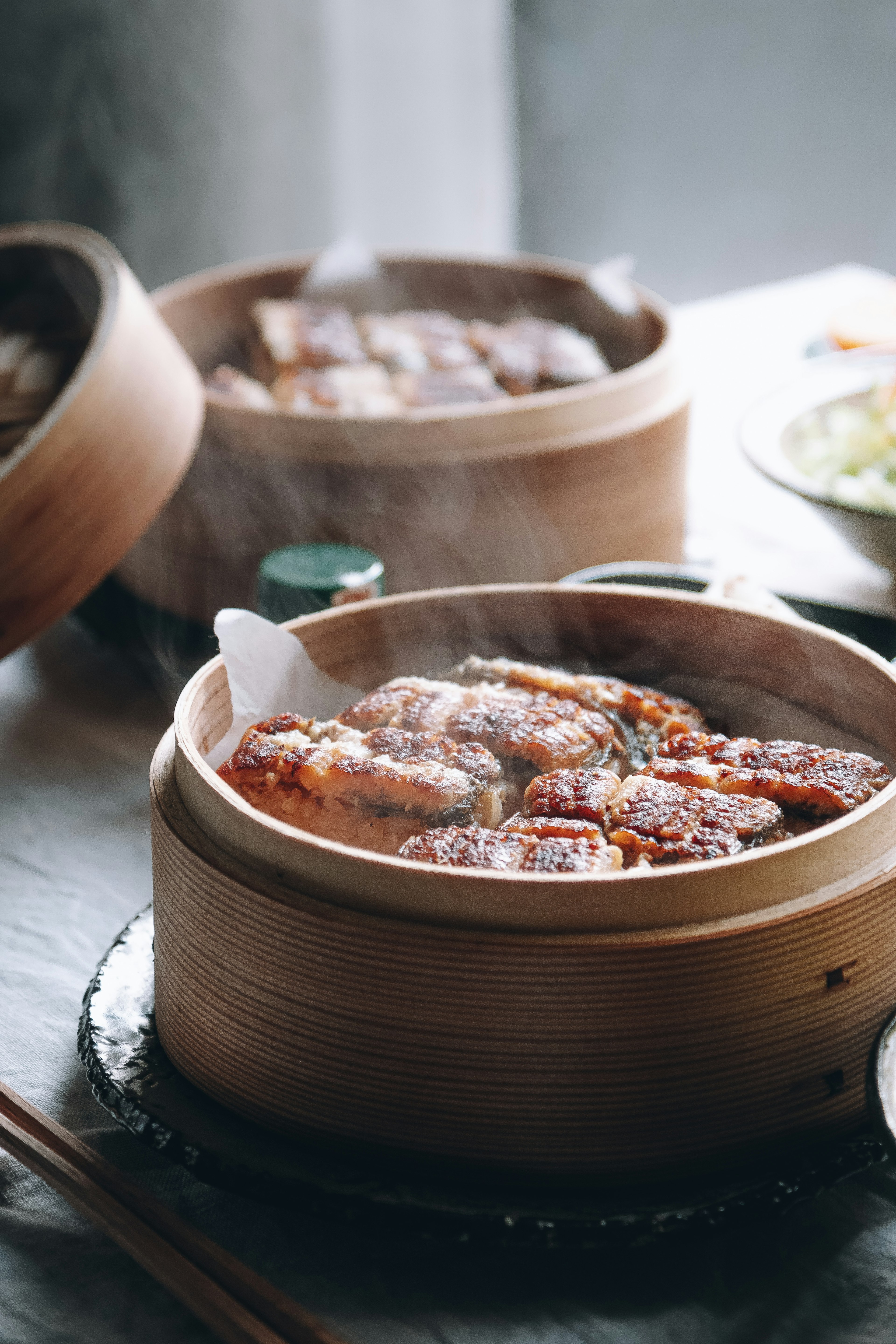 Bamboo steamers filled with steamed dishes emitting steam