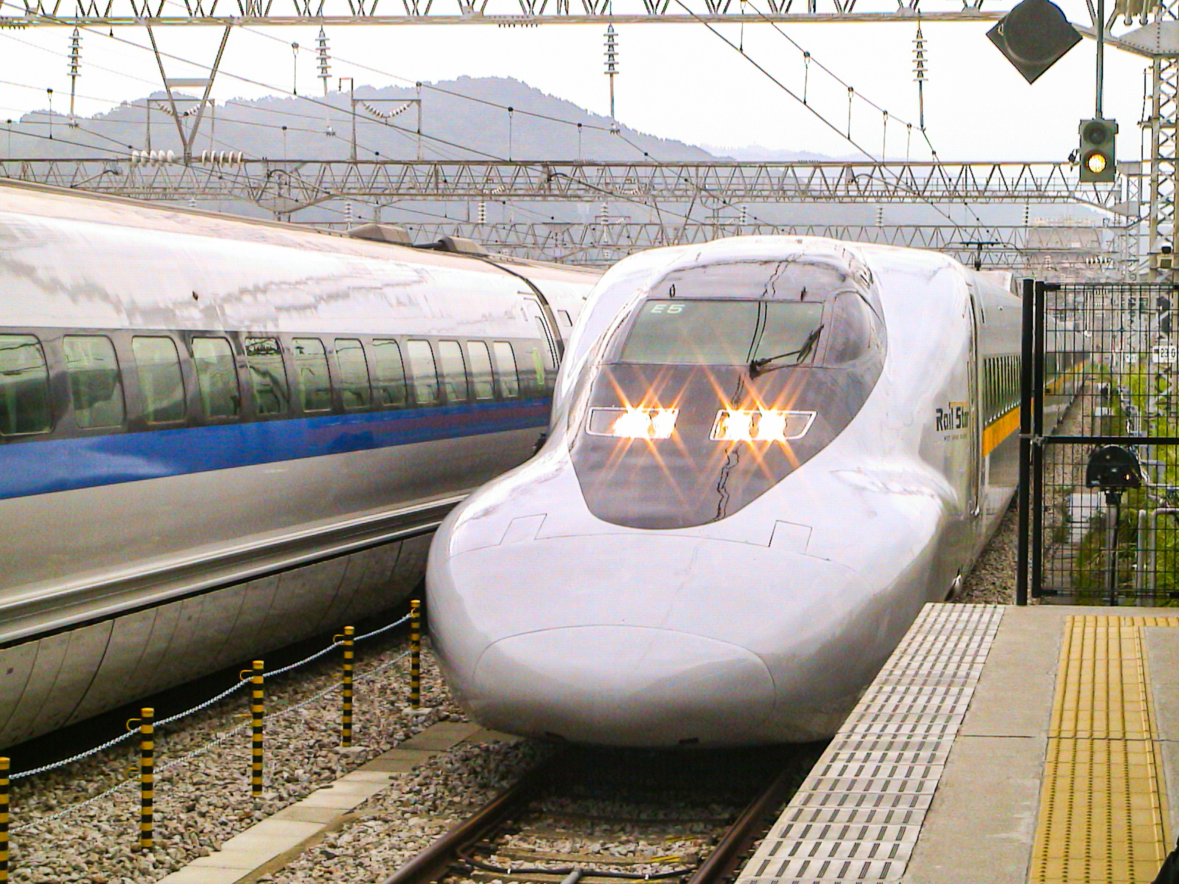 新幹線の駅で停車中の白い高速列車