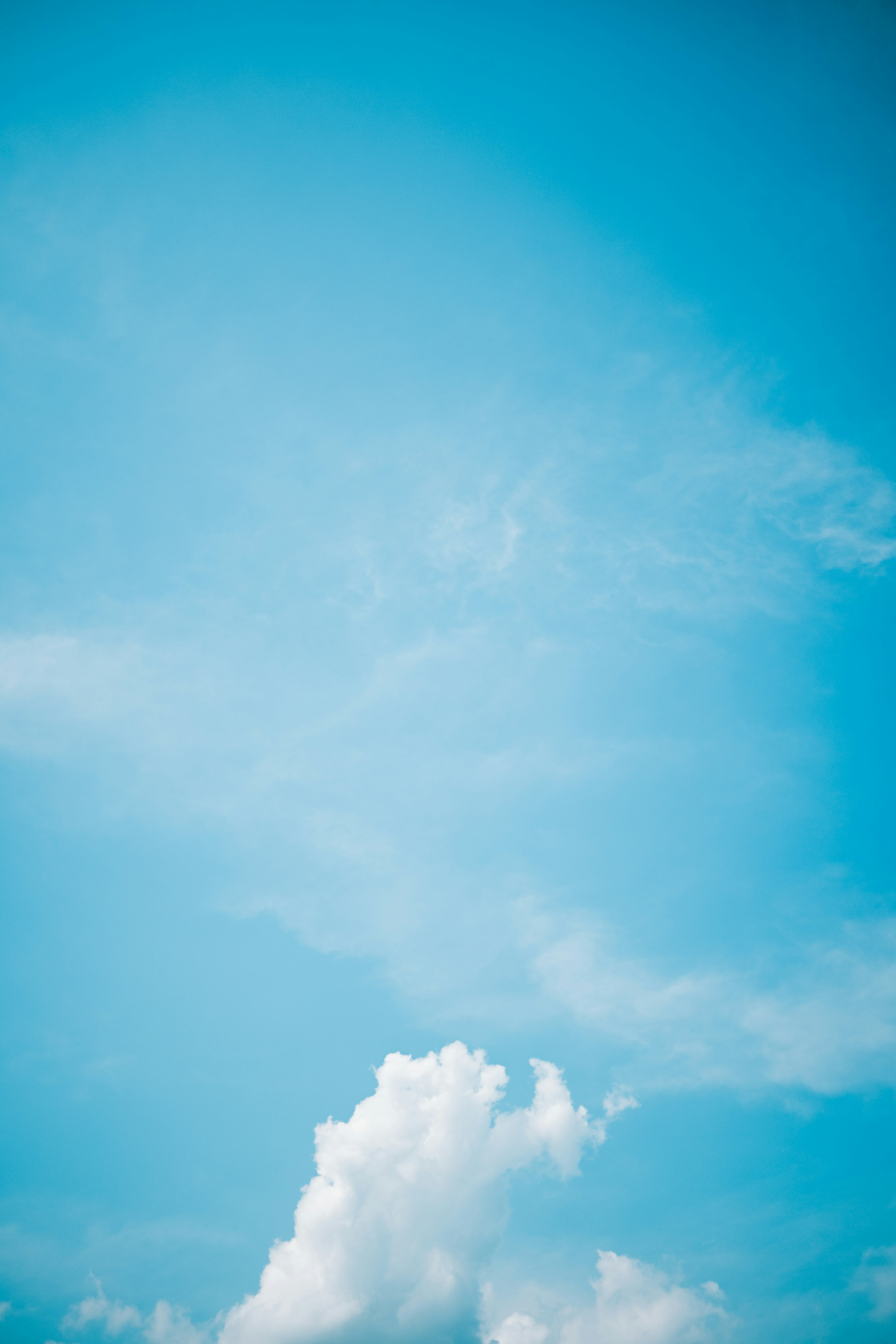 A clear blue sky with fluffy white clouds