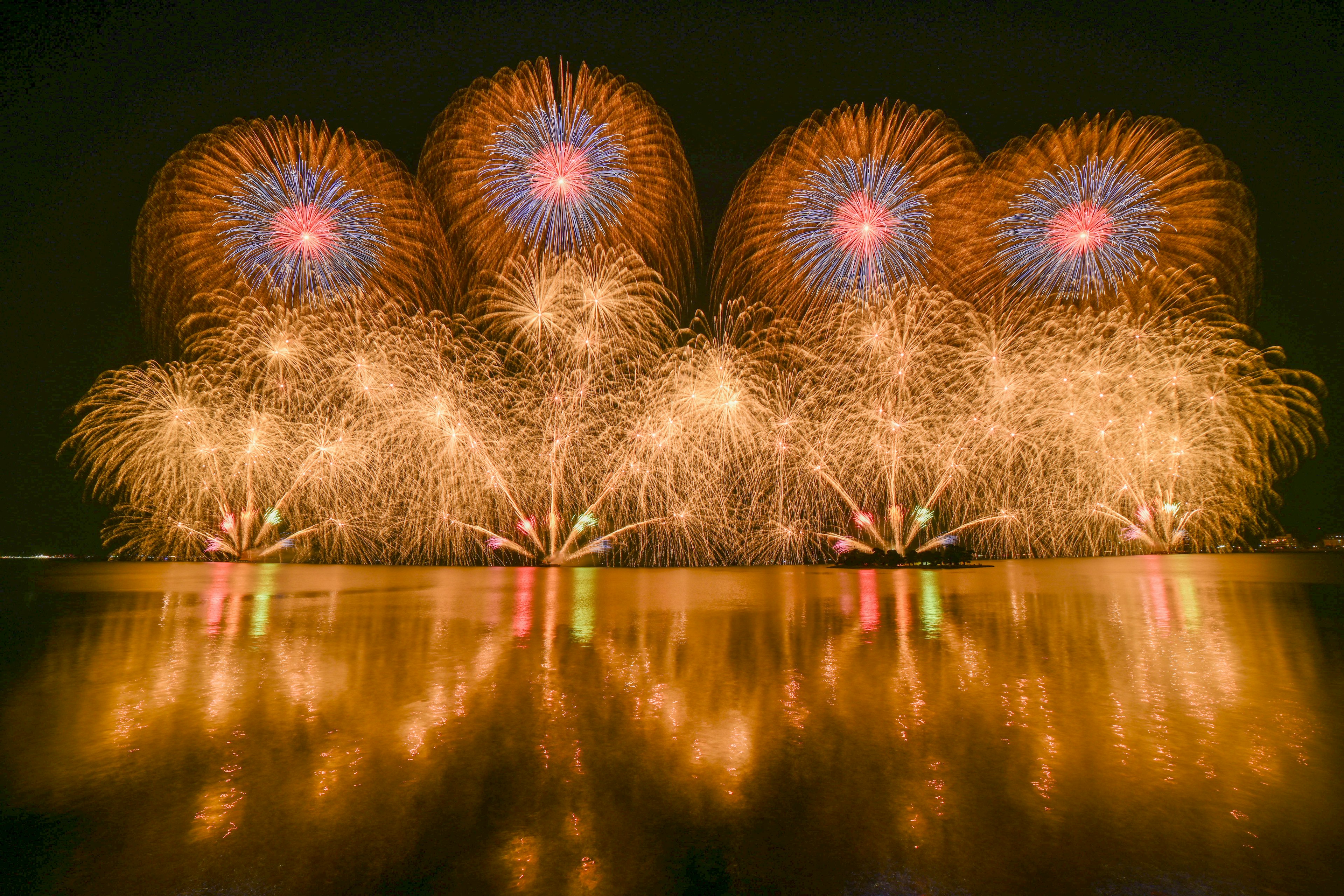 夜空中绚丽的烟花在水面上反射