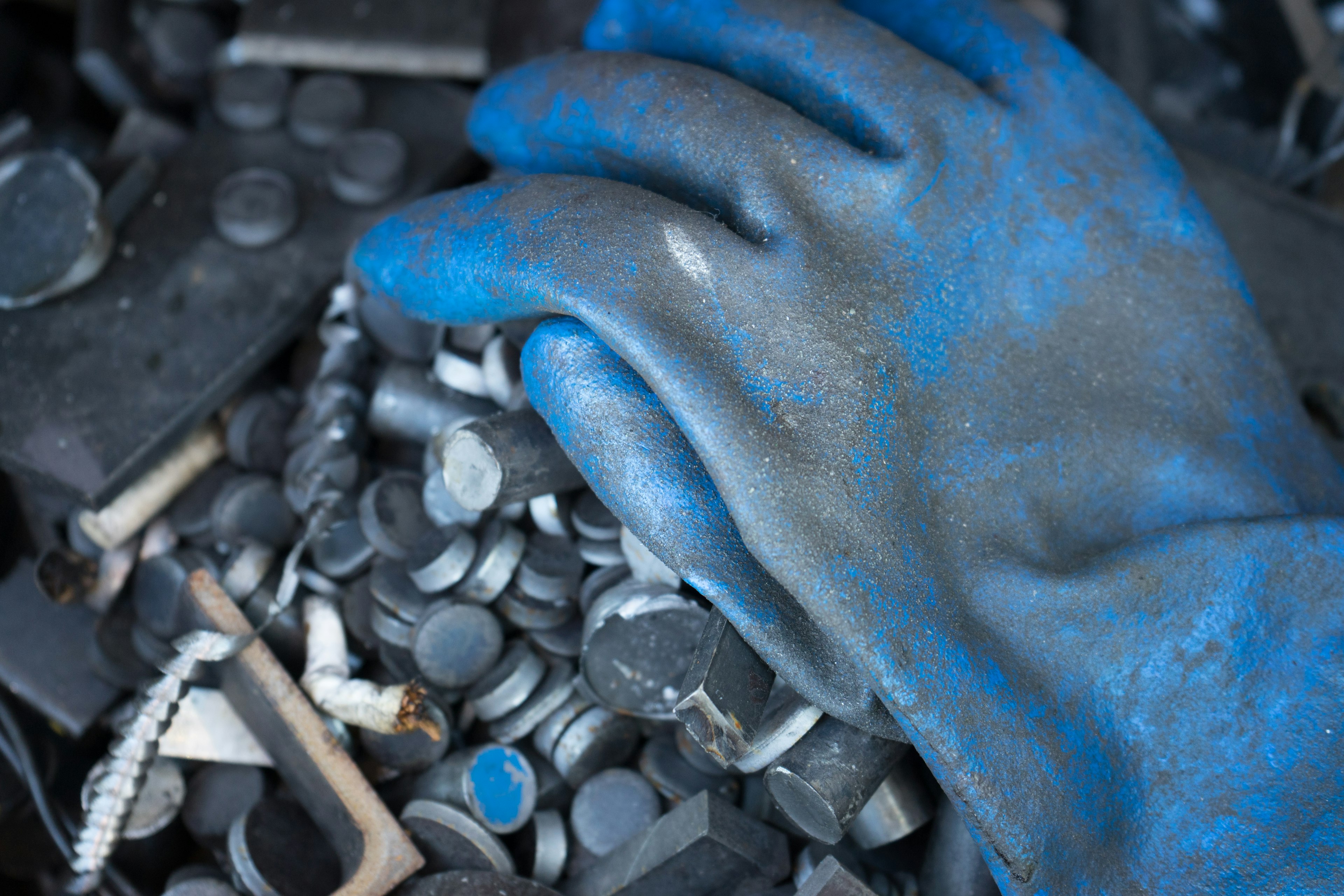 Une main gantée de bleu reposant sur un tas de composants noirs