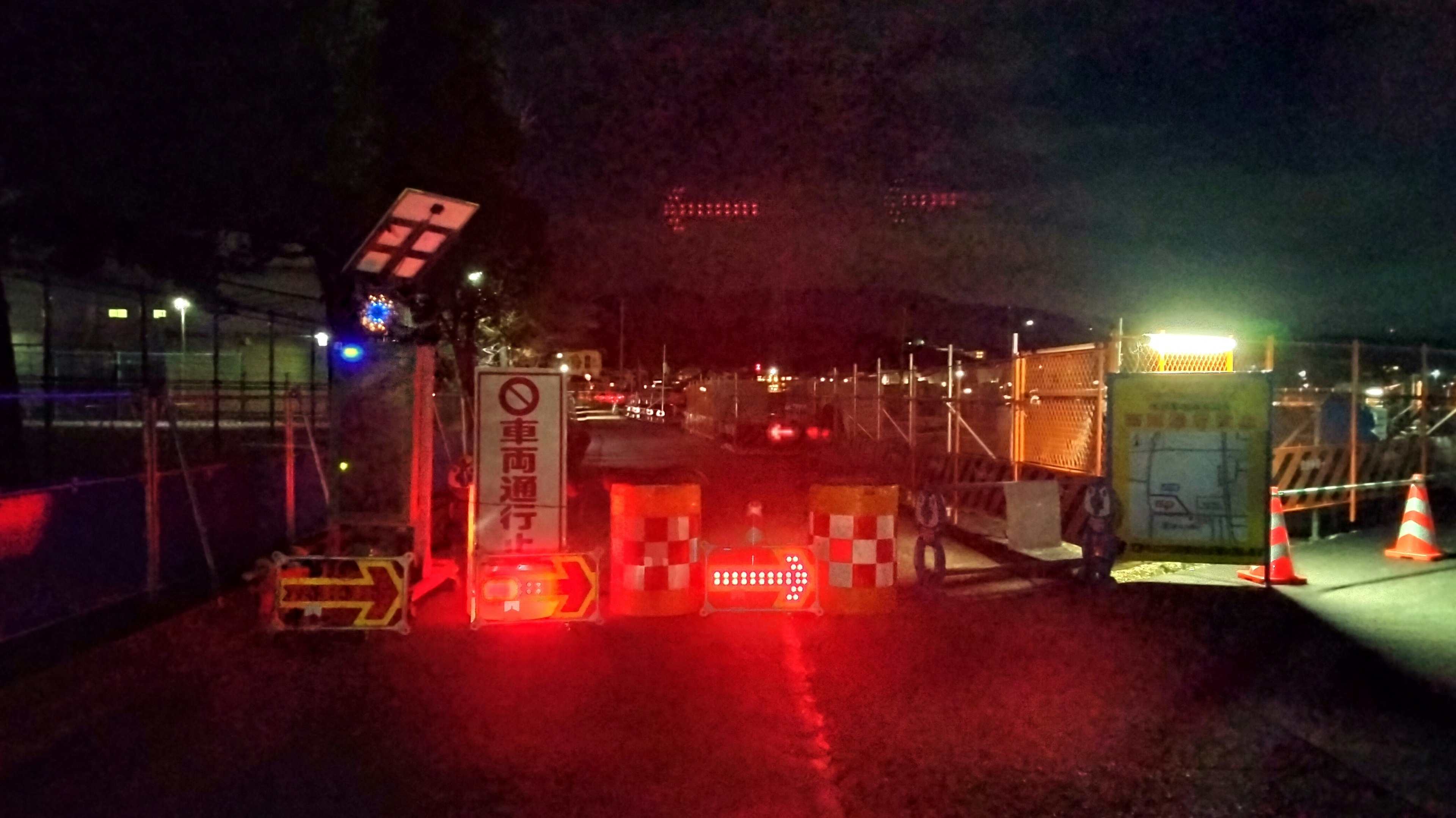 Night construction site barricade with red lights