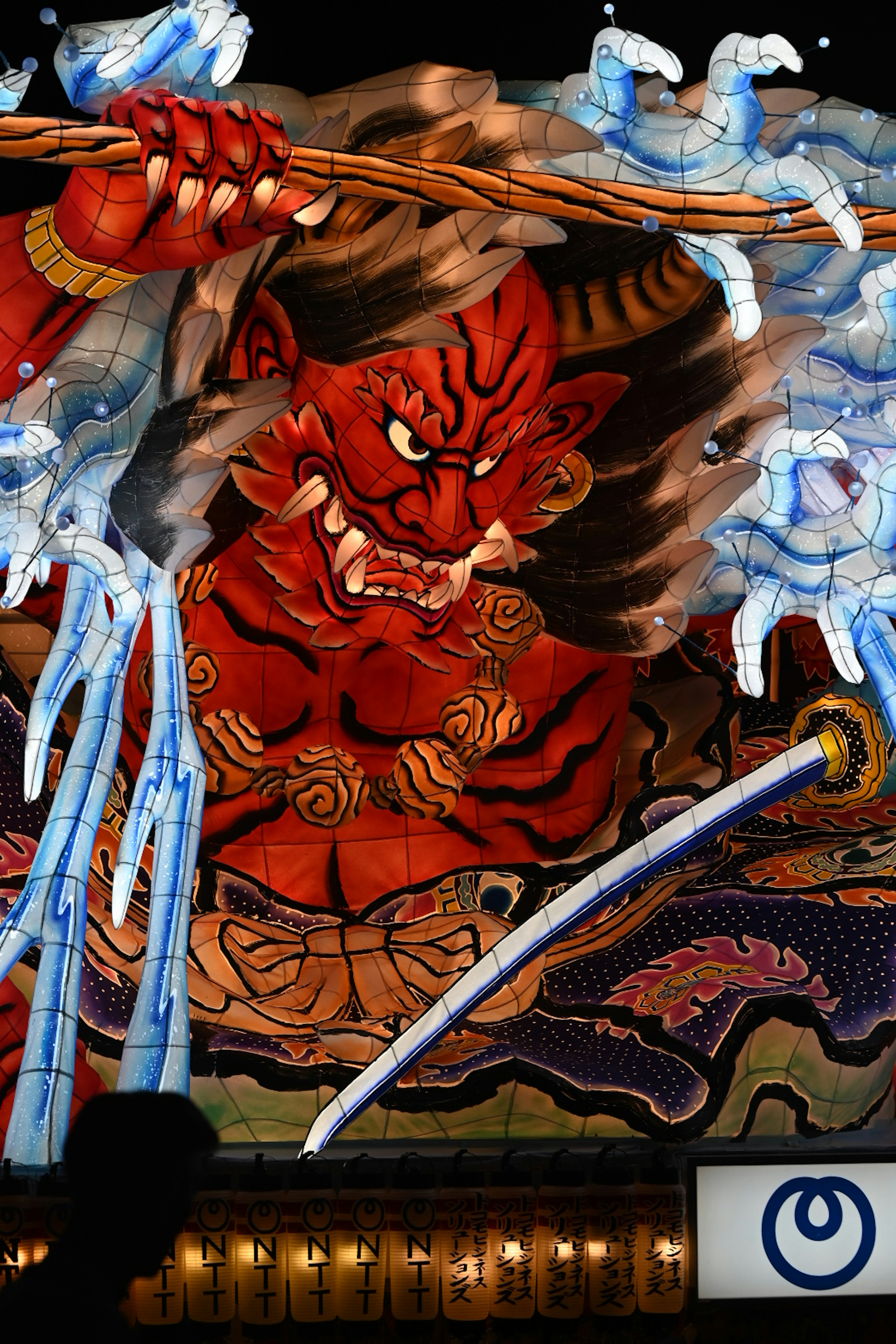 Imposing artwork of a red demon lifting water with a sword