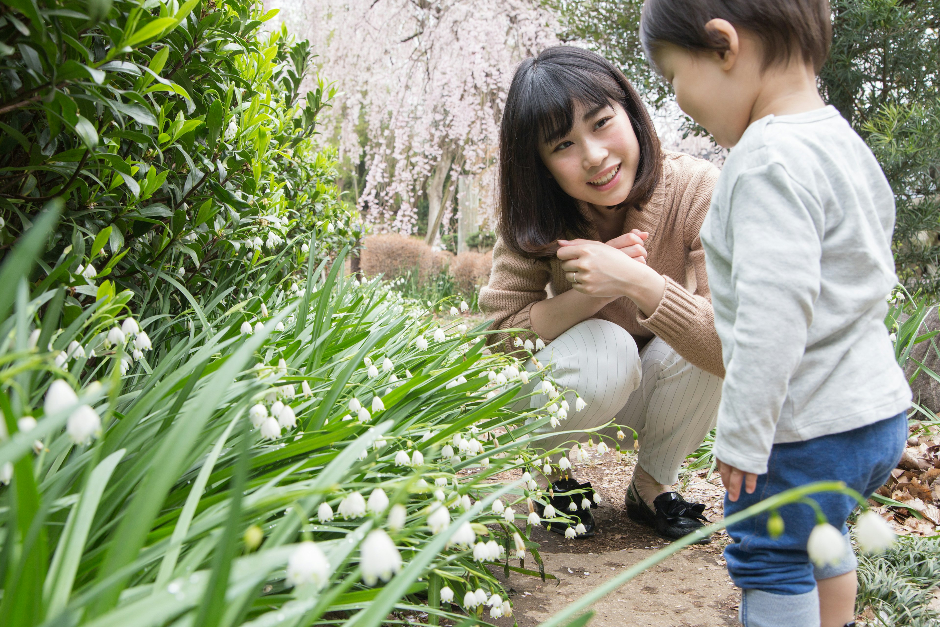 Eine Mutter und ihr Kind genießen Blumen in einem Garten