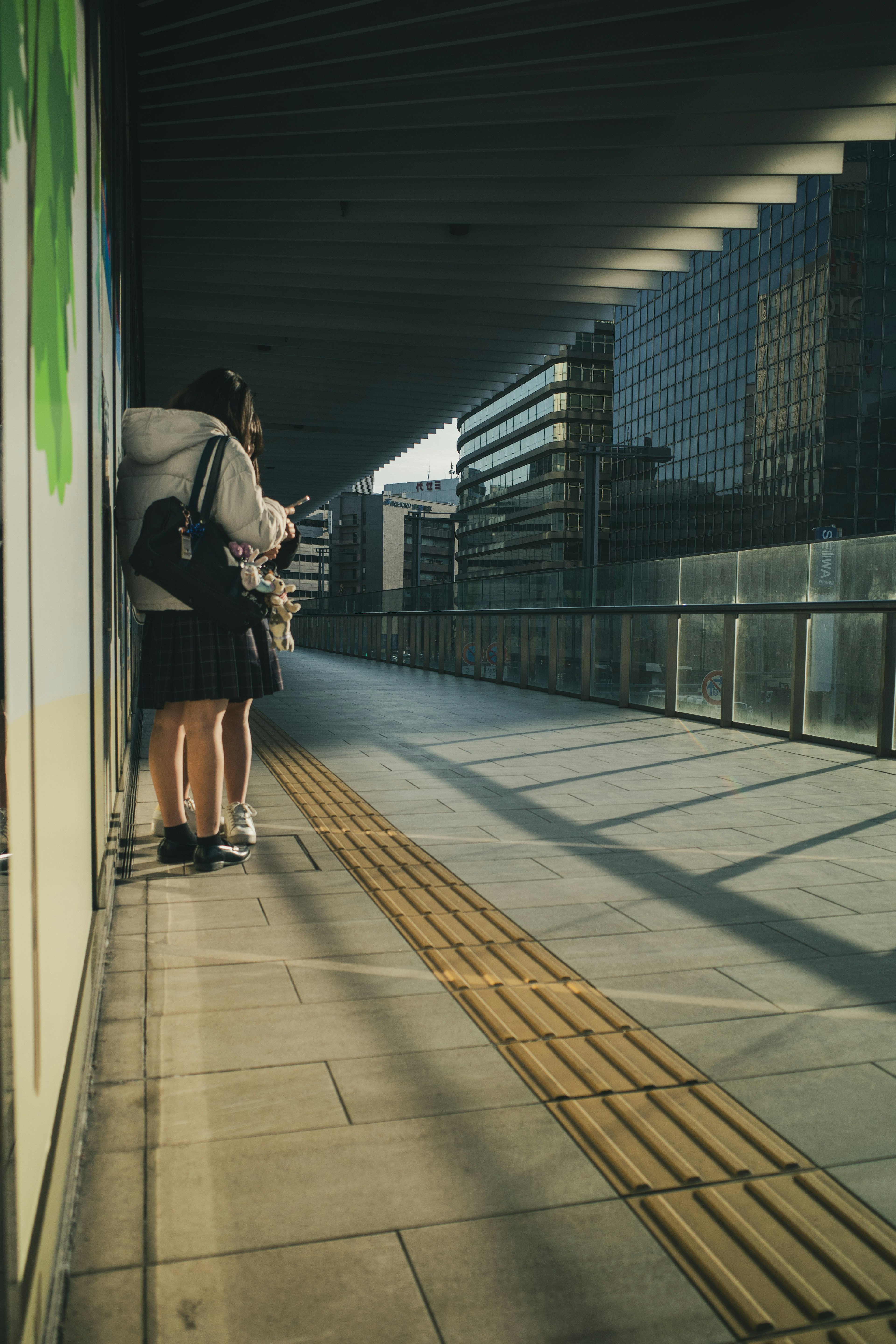 Vista posteriore di studenti in uniforme in piedi su un marciapiede di città