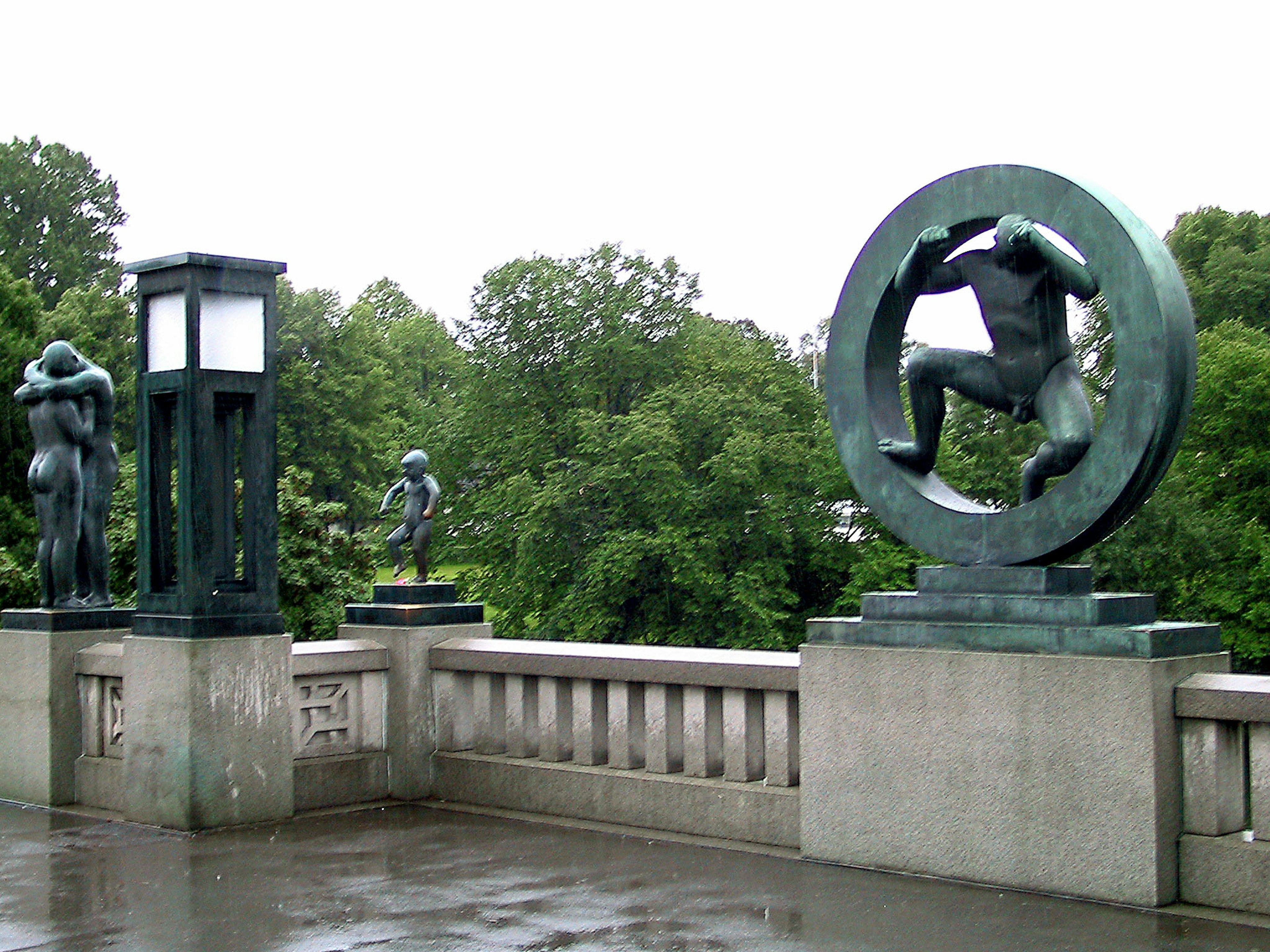 Vista di un ponte con sculture circondate da vegetazione in pose varie