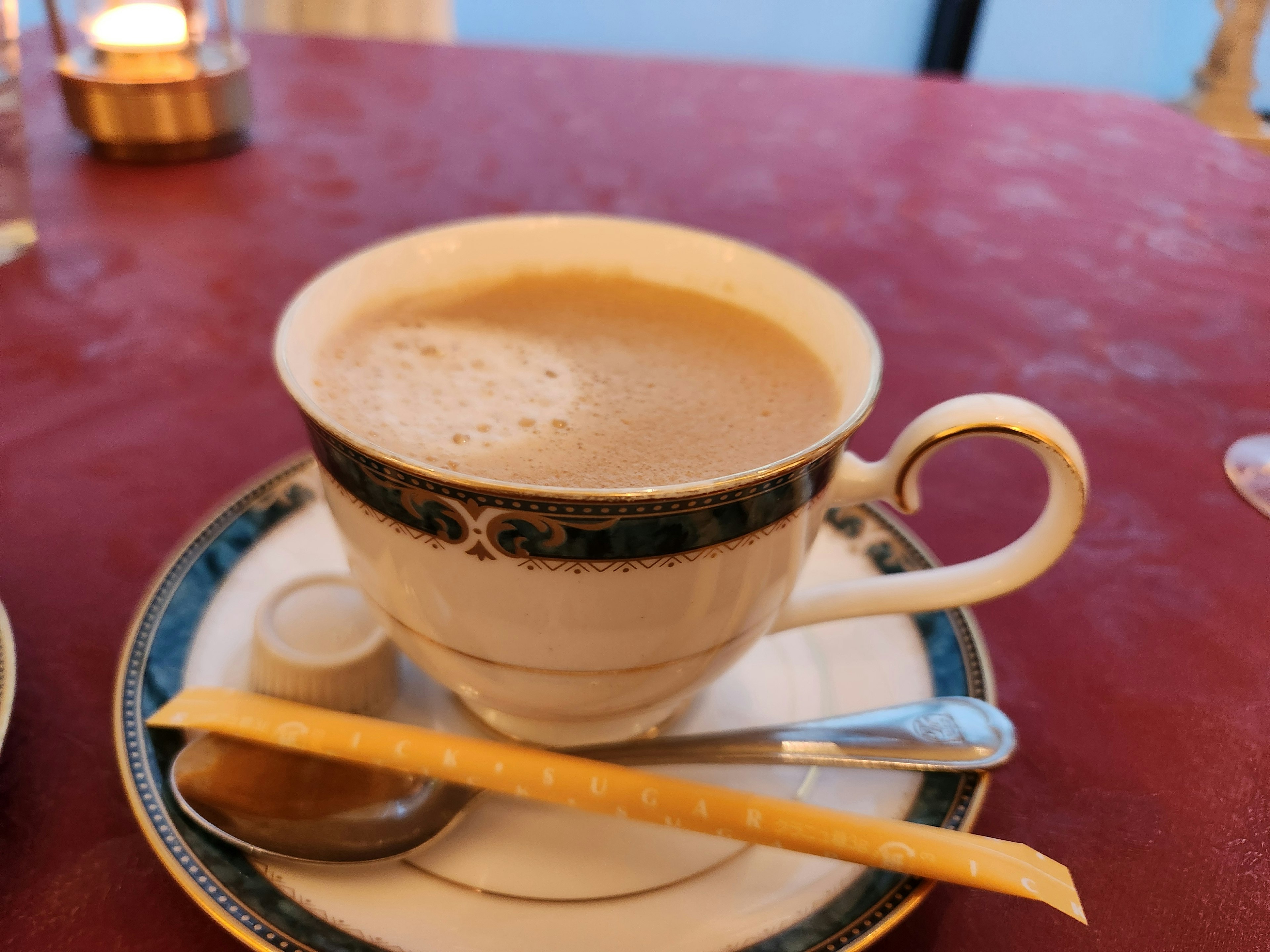 Creamy coffee in an elegant cup with a biscuit stick on a plate