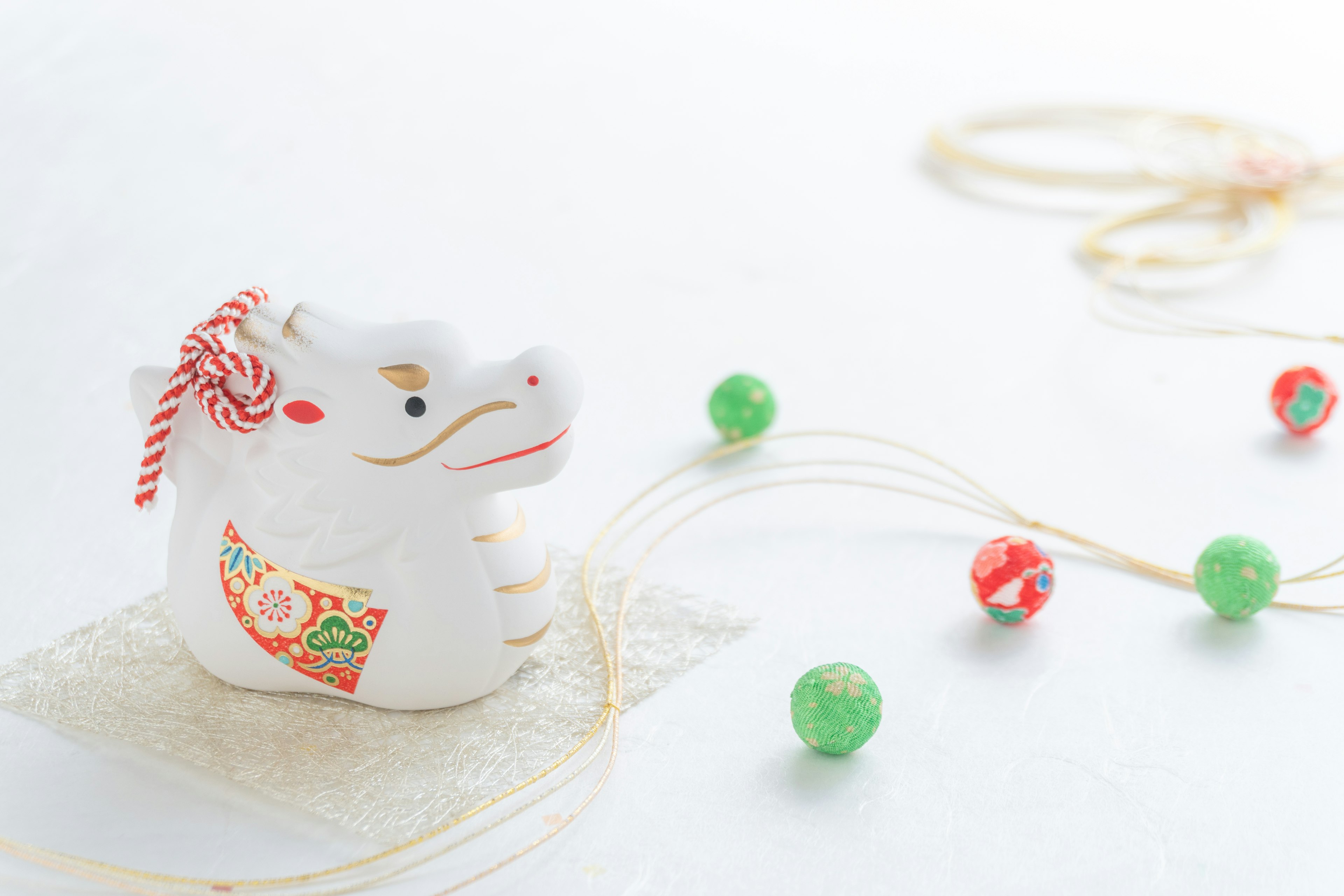 A cute white cow figurine with colorful beads on a white background