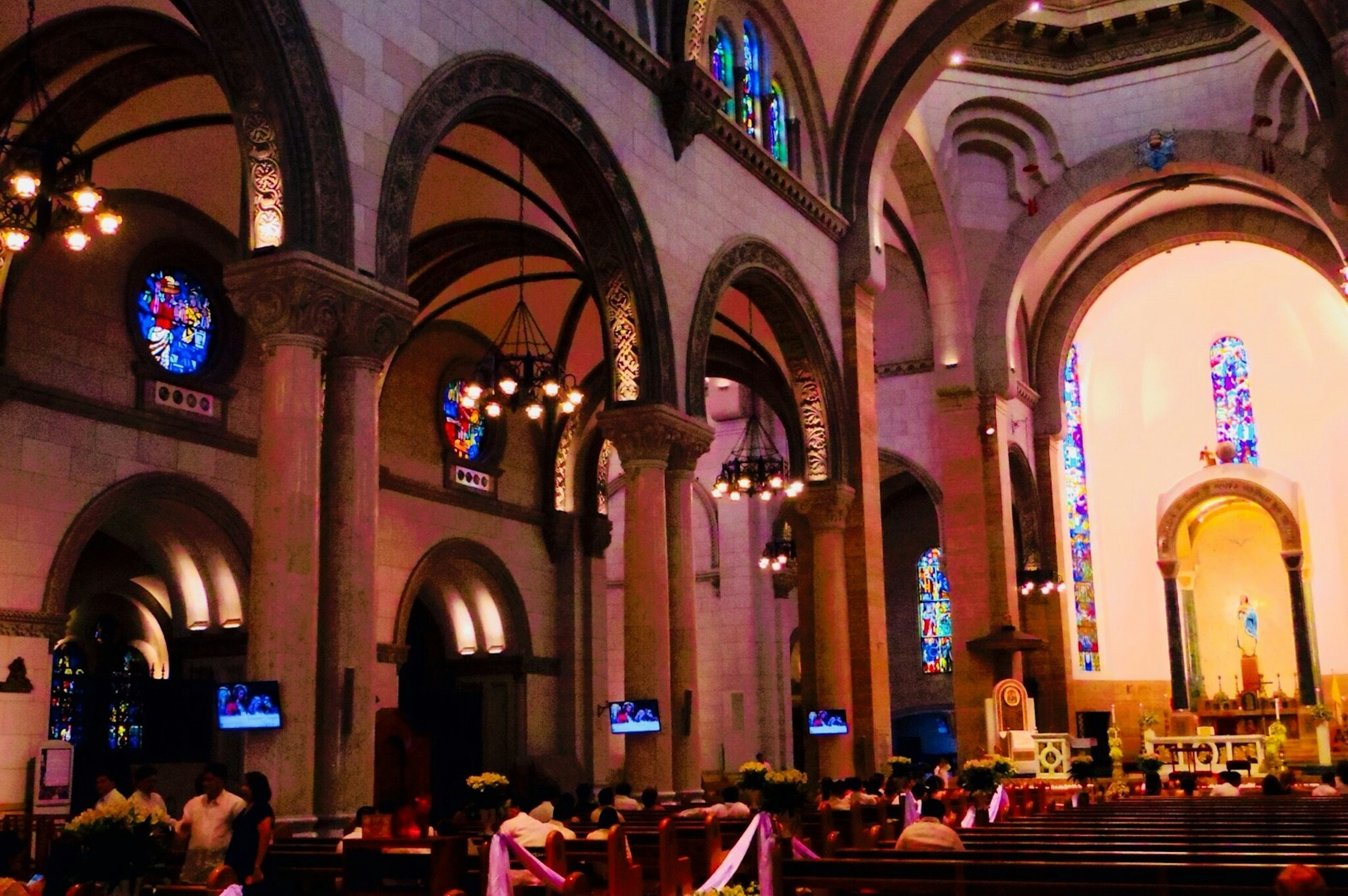 Innenraum einer Kirche mit schönen Buntglasfenstern und beeindruckenden gewölbten Decken