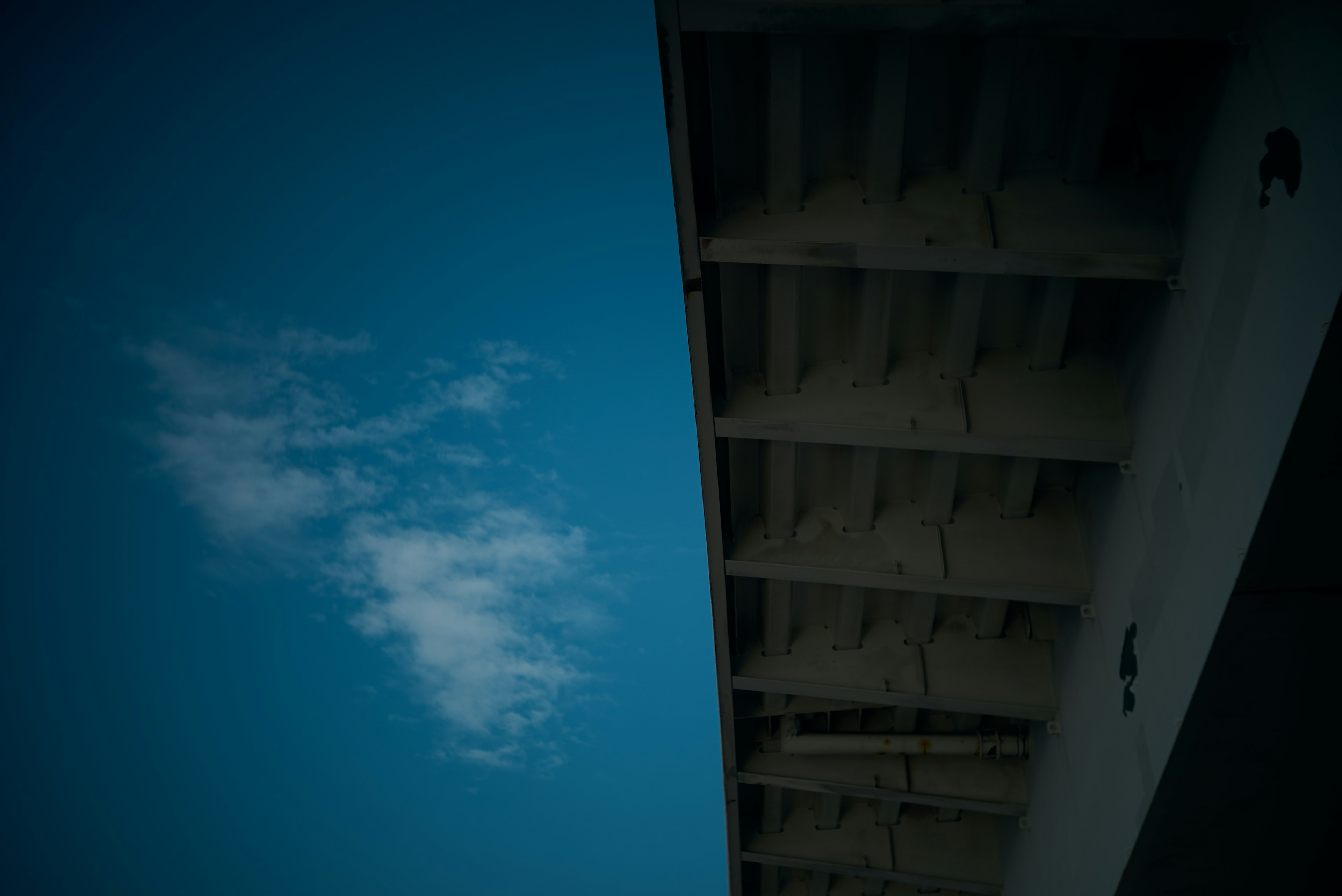 青空と白い雲が見える建物の一部