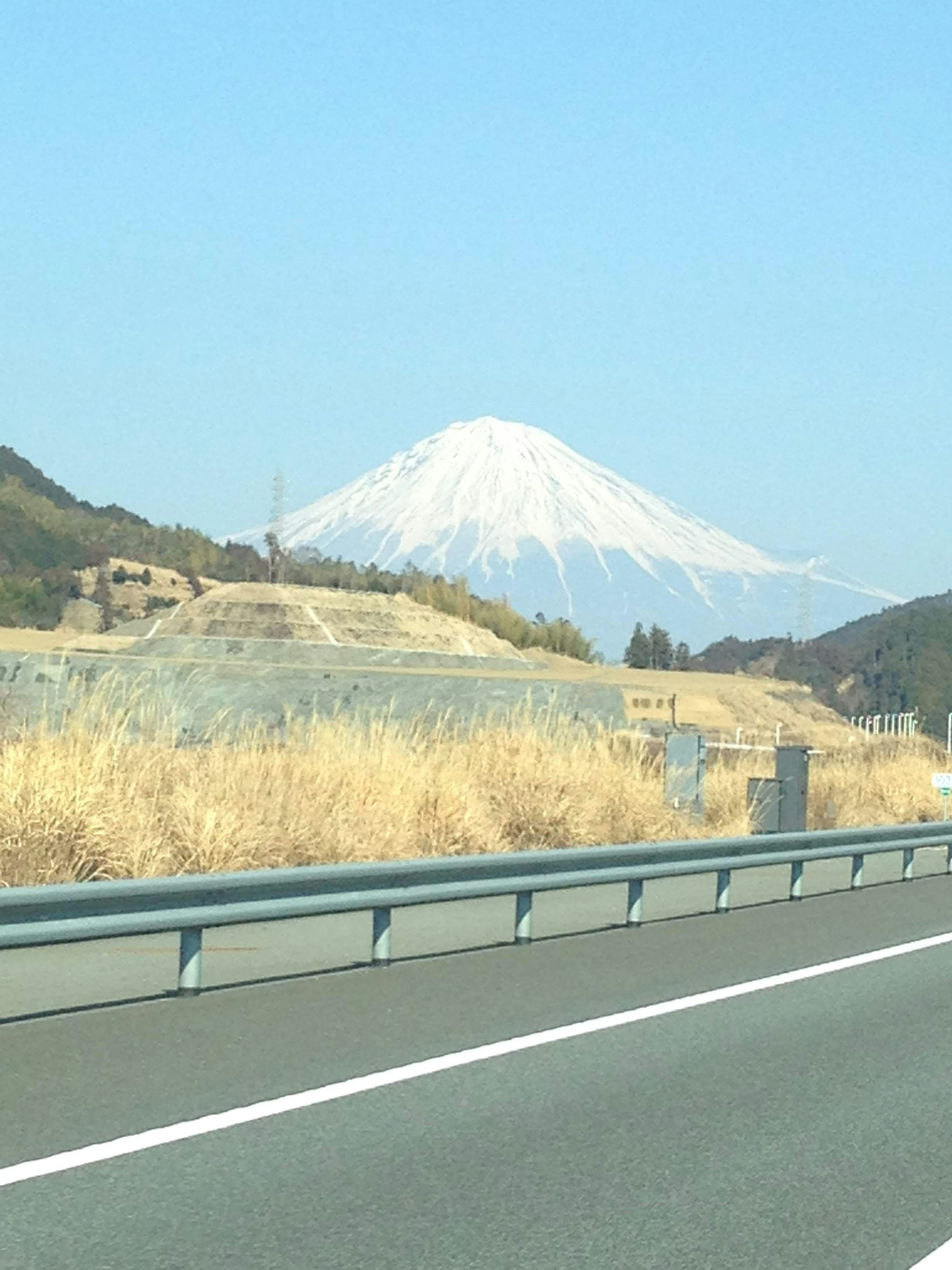 雪をかぶった富士山が見える道路の風景