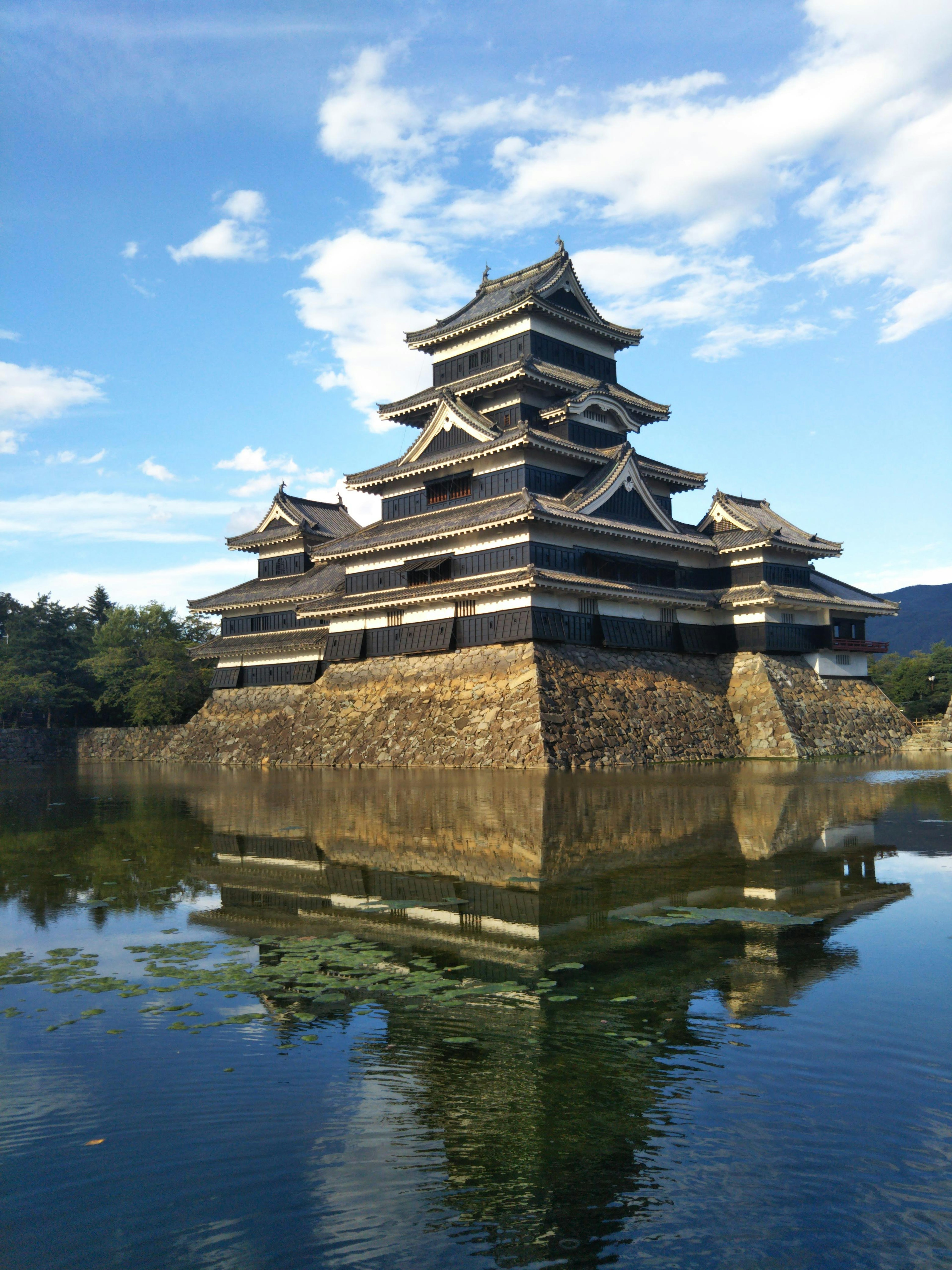 Castillo de Matsumoto rodeado de agua y cielo azul