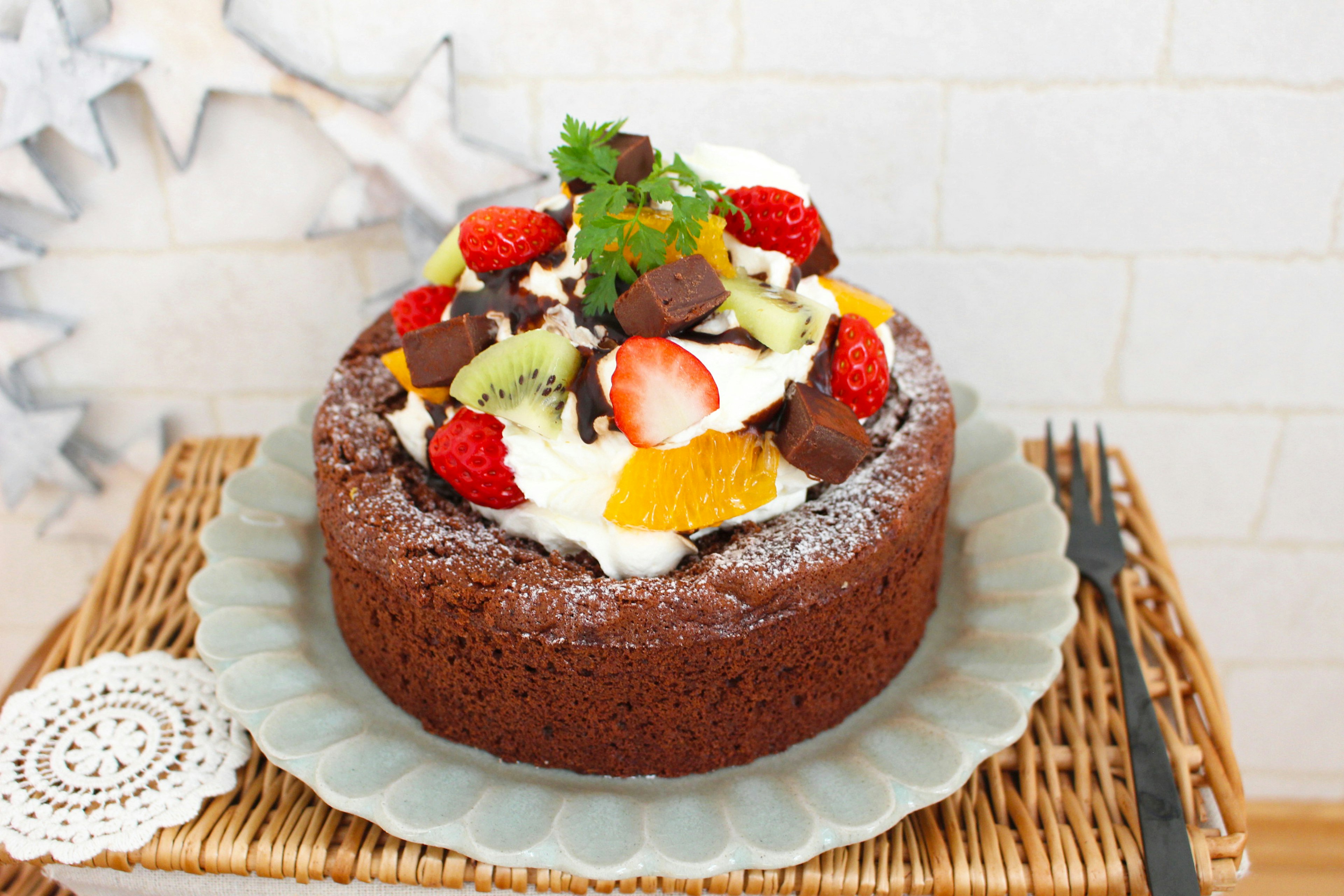 Pastel de chocolate cubierto con frutas y crema