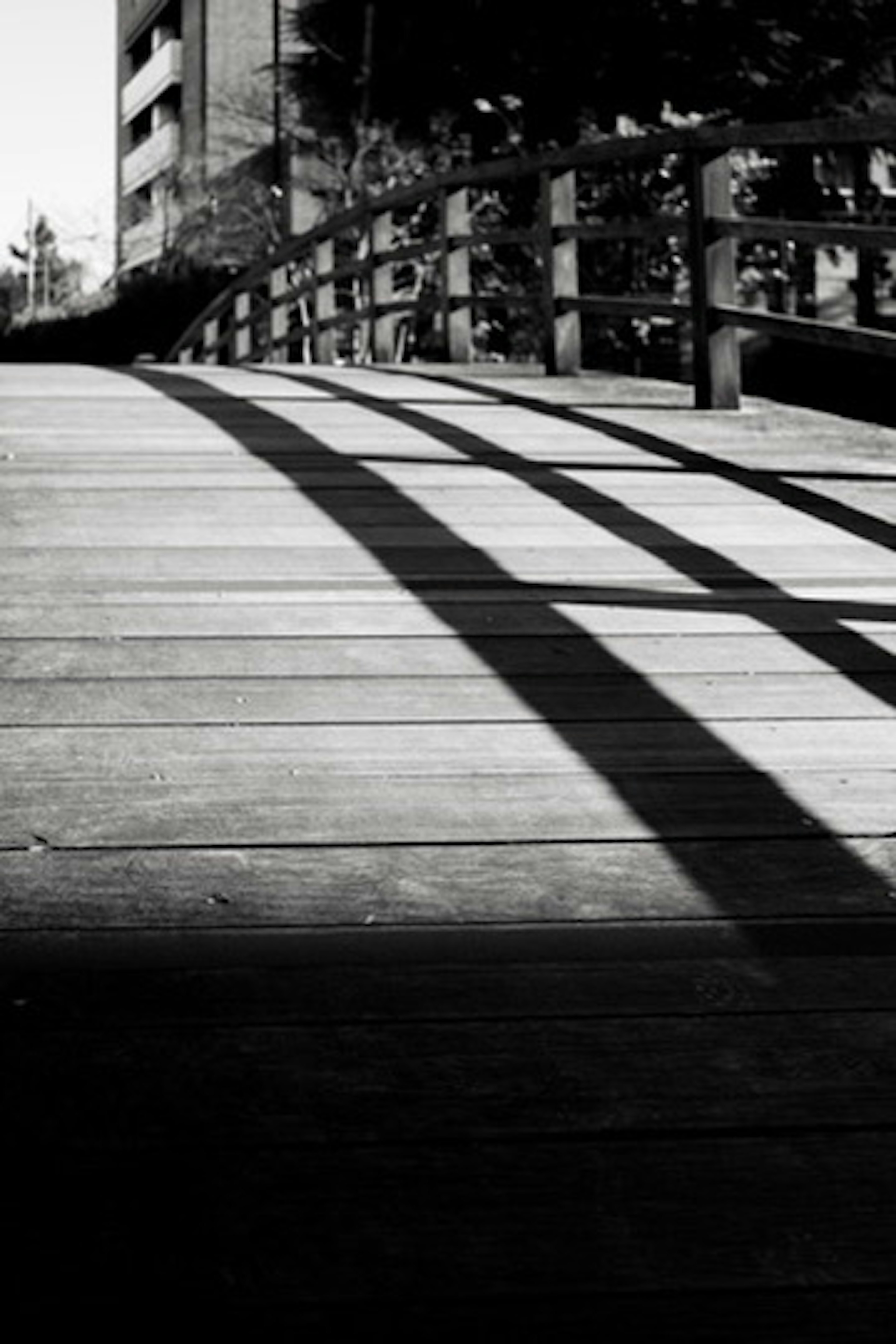 Black and white image of a wooden bridge with shadows