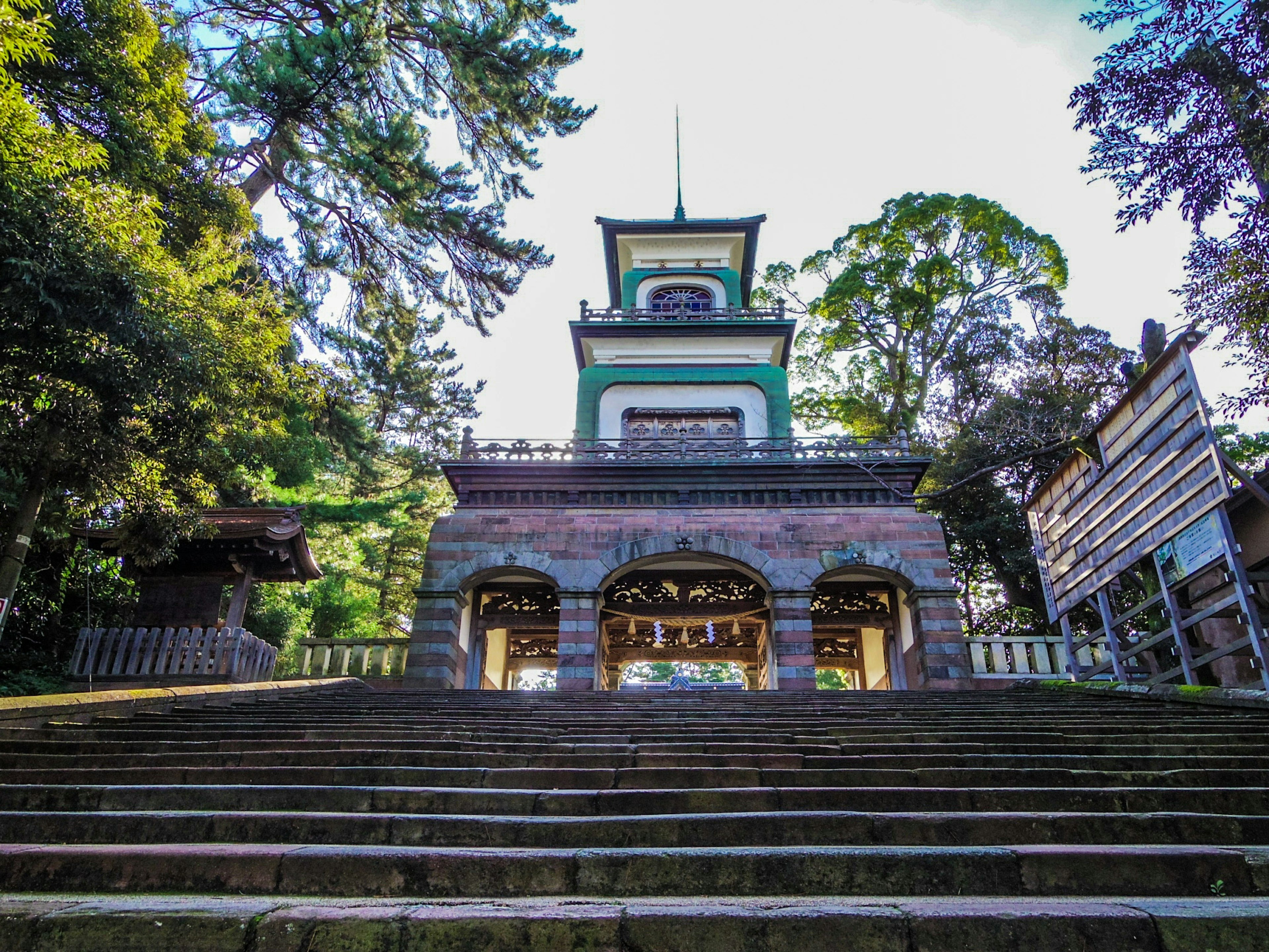 Bâtiment traditionnel magnifique entouré de verdure au sommet des escaliers