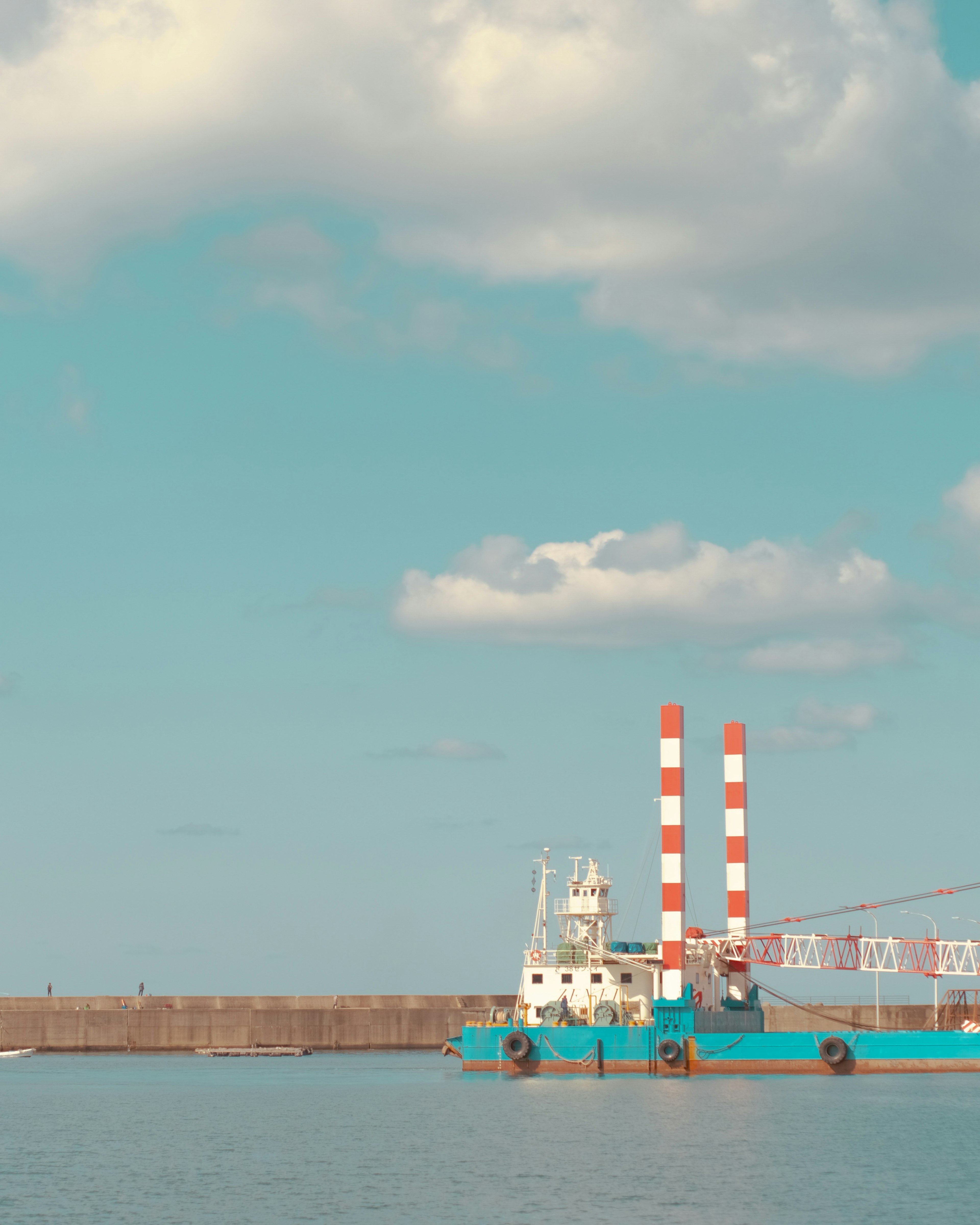 Blue boat with red and white smokestacks near harbor