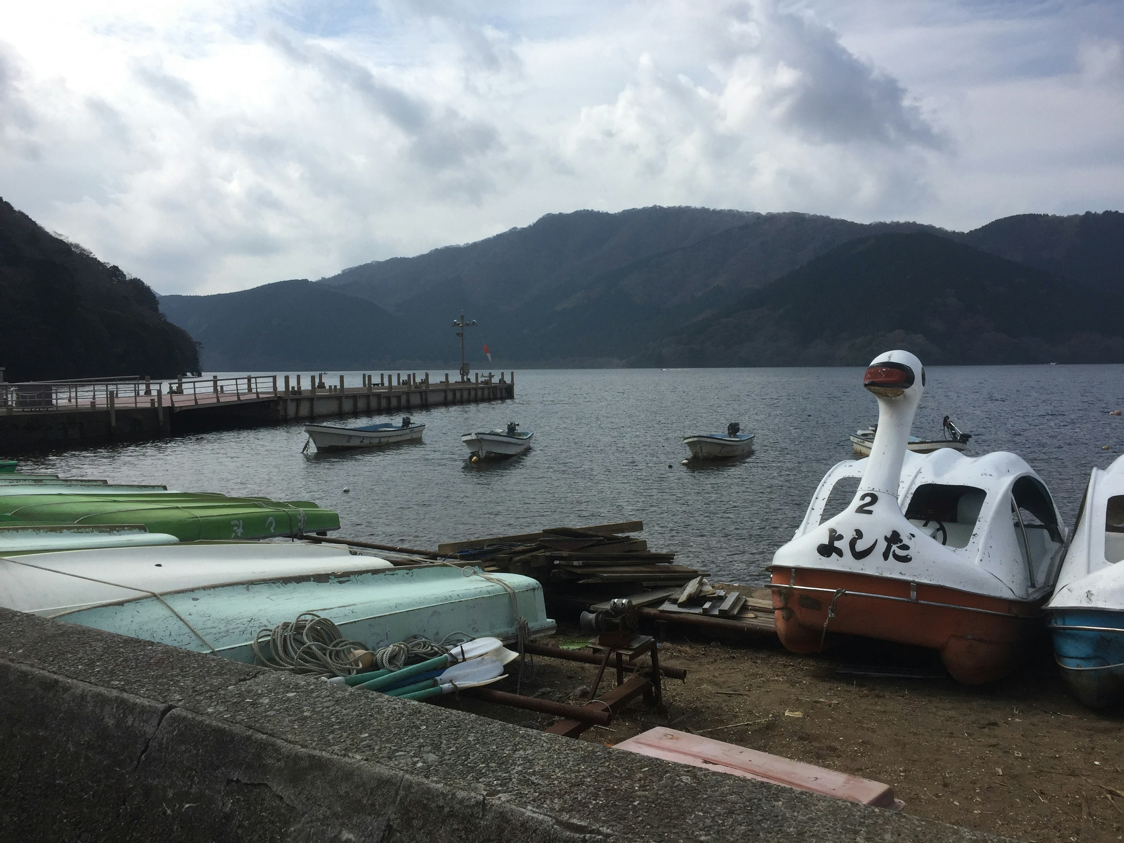 Barche a lago con montagne sullo sfondo