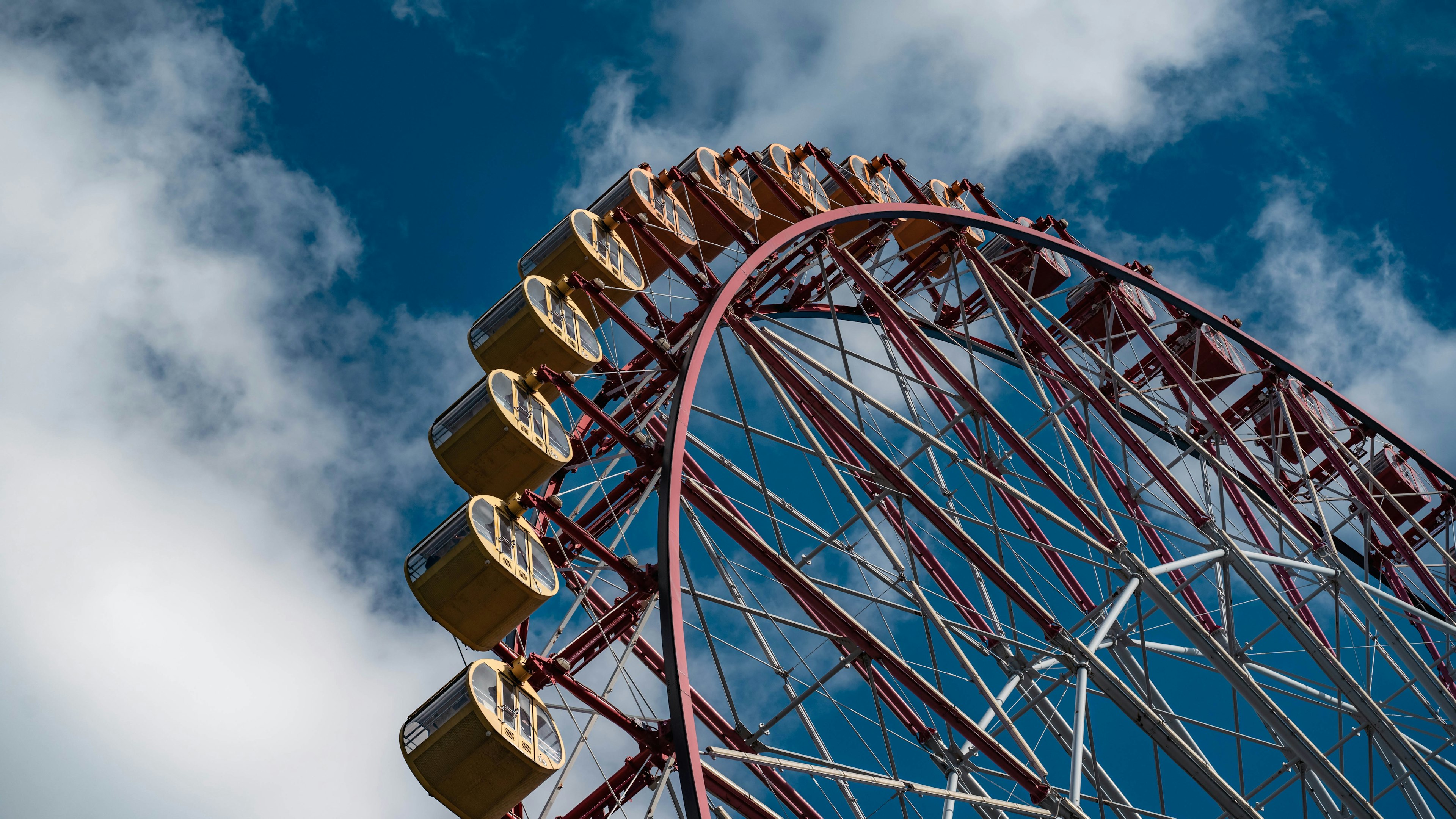 Ferris wheel against a blue sky with clouds