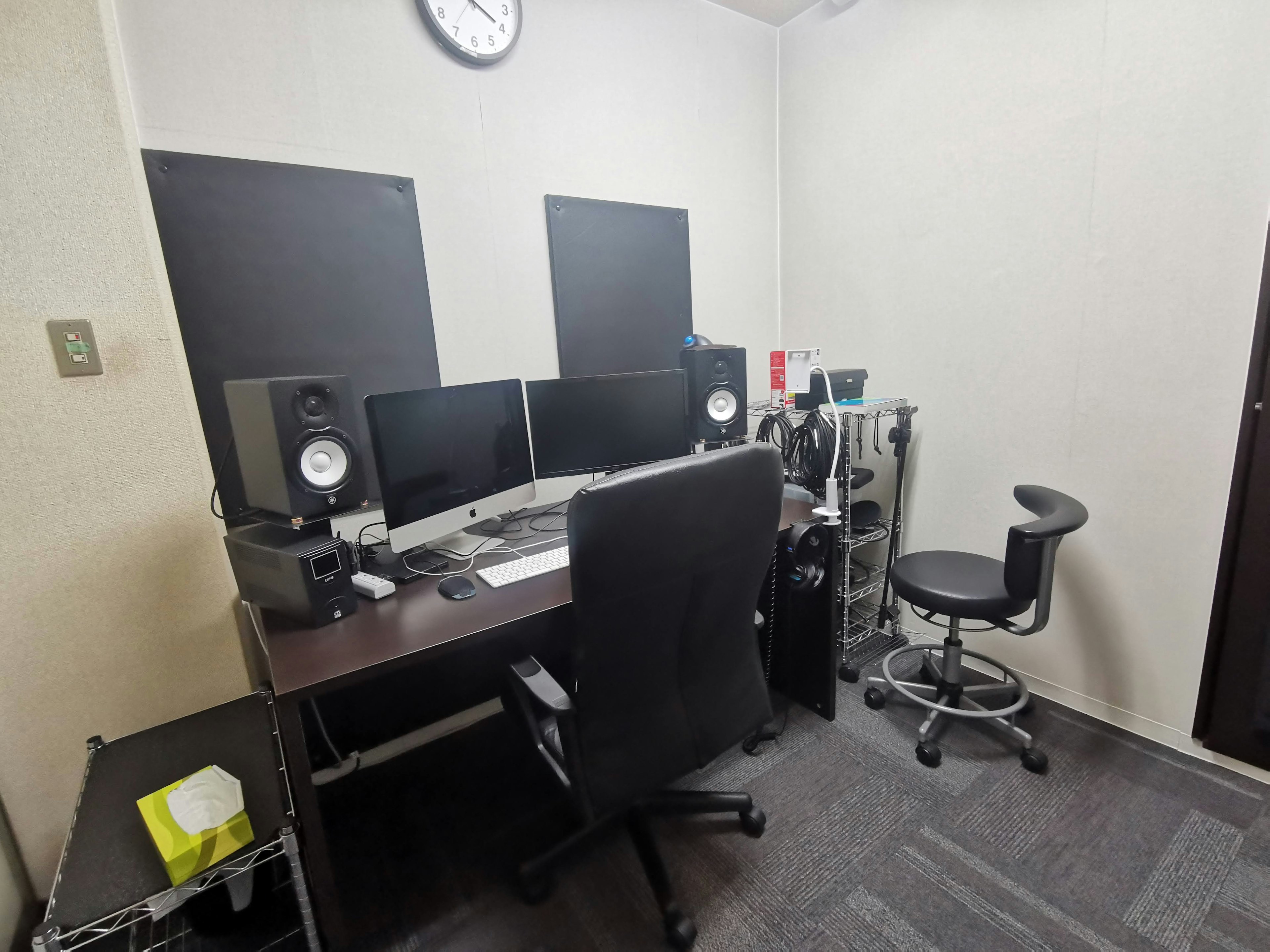 Minimalist office space featuring dual monitors and speakers on a desk