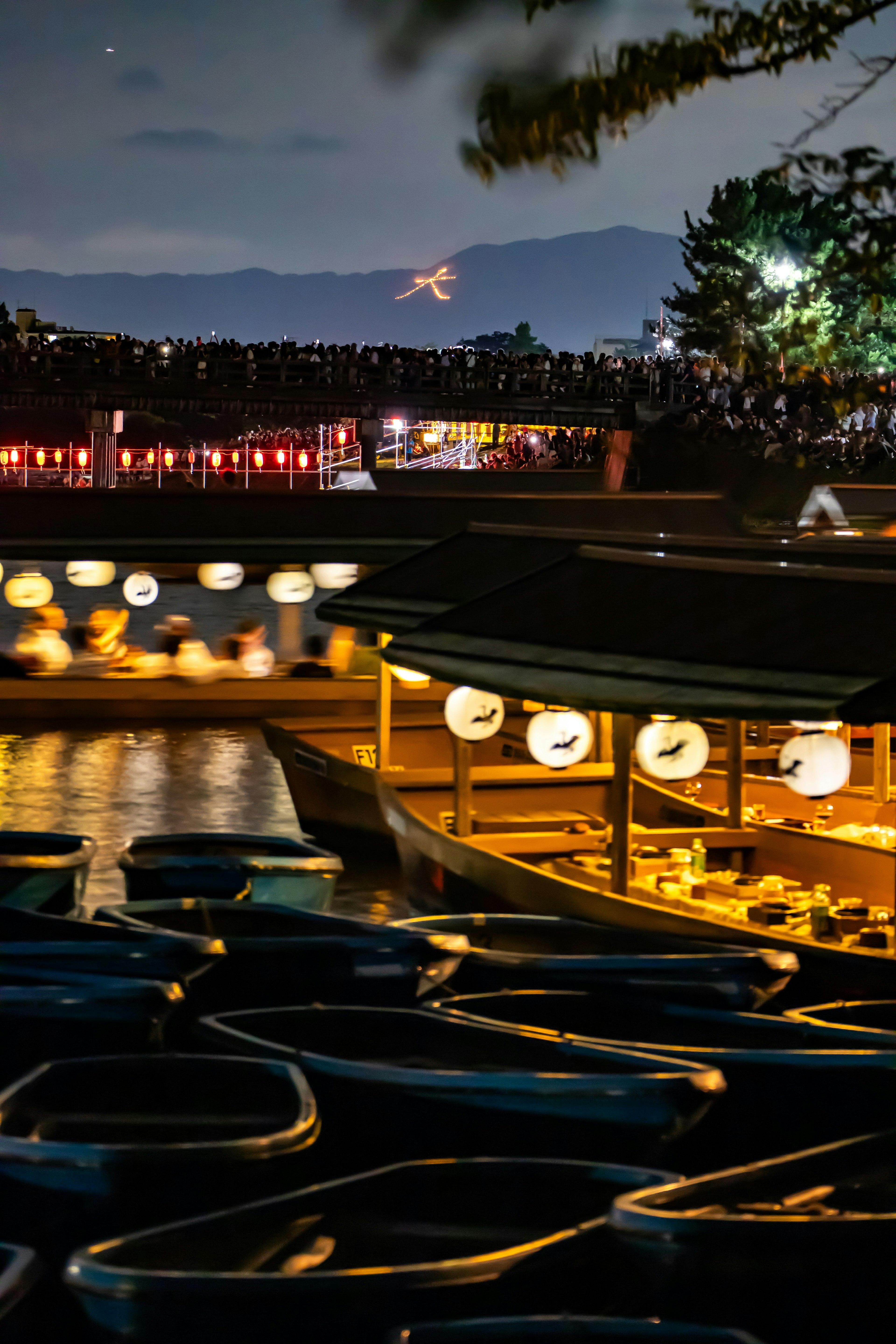 夜の湖に浮かぶボートと灯篭の光