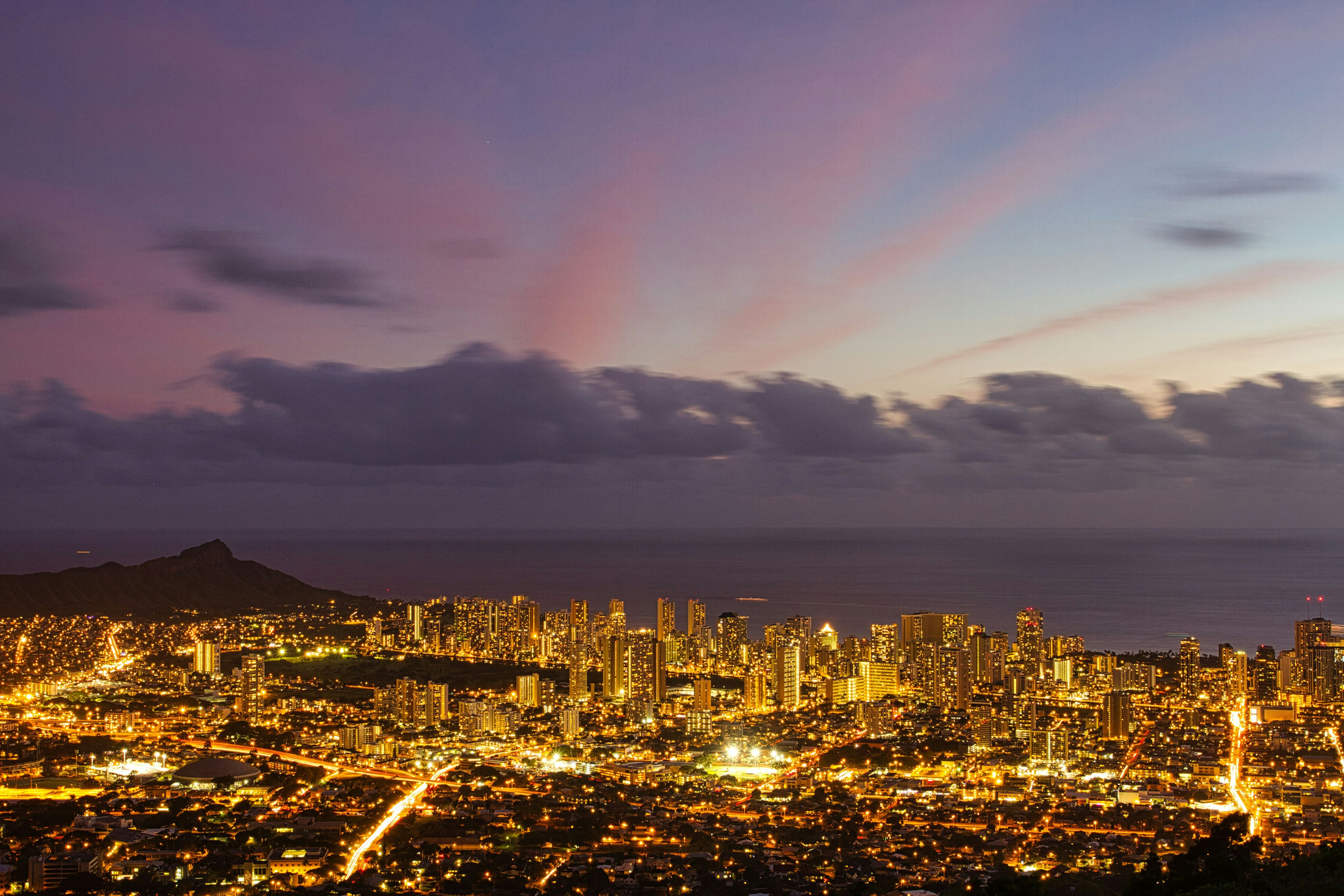 Vista crepuscolare di Honolulu con skyline illuminato e oceano