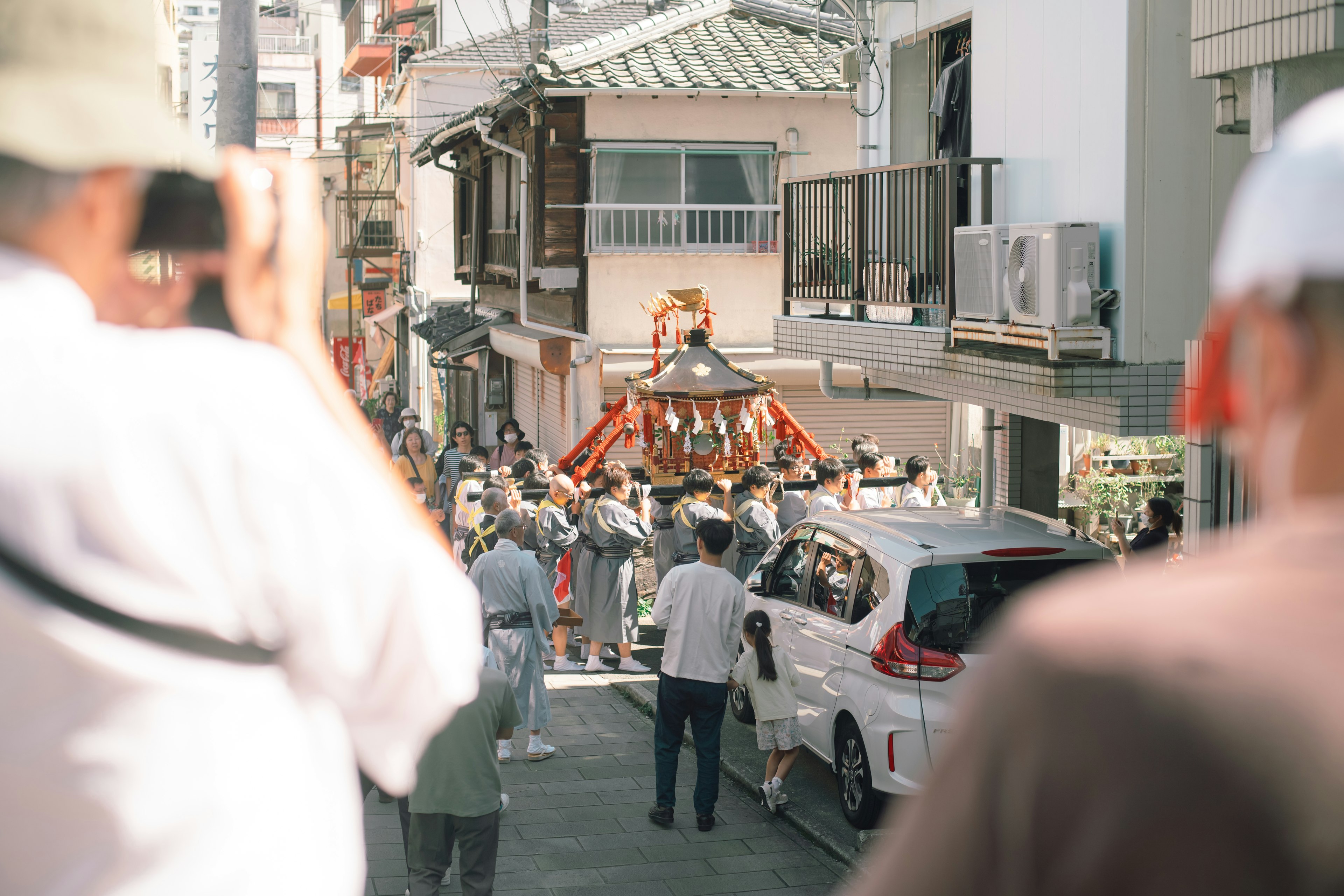 祭りのパレードで人々が集まっている街の風景