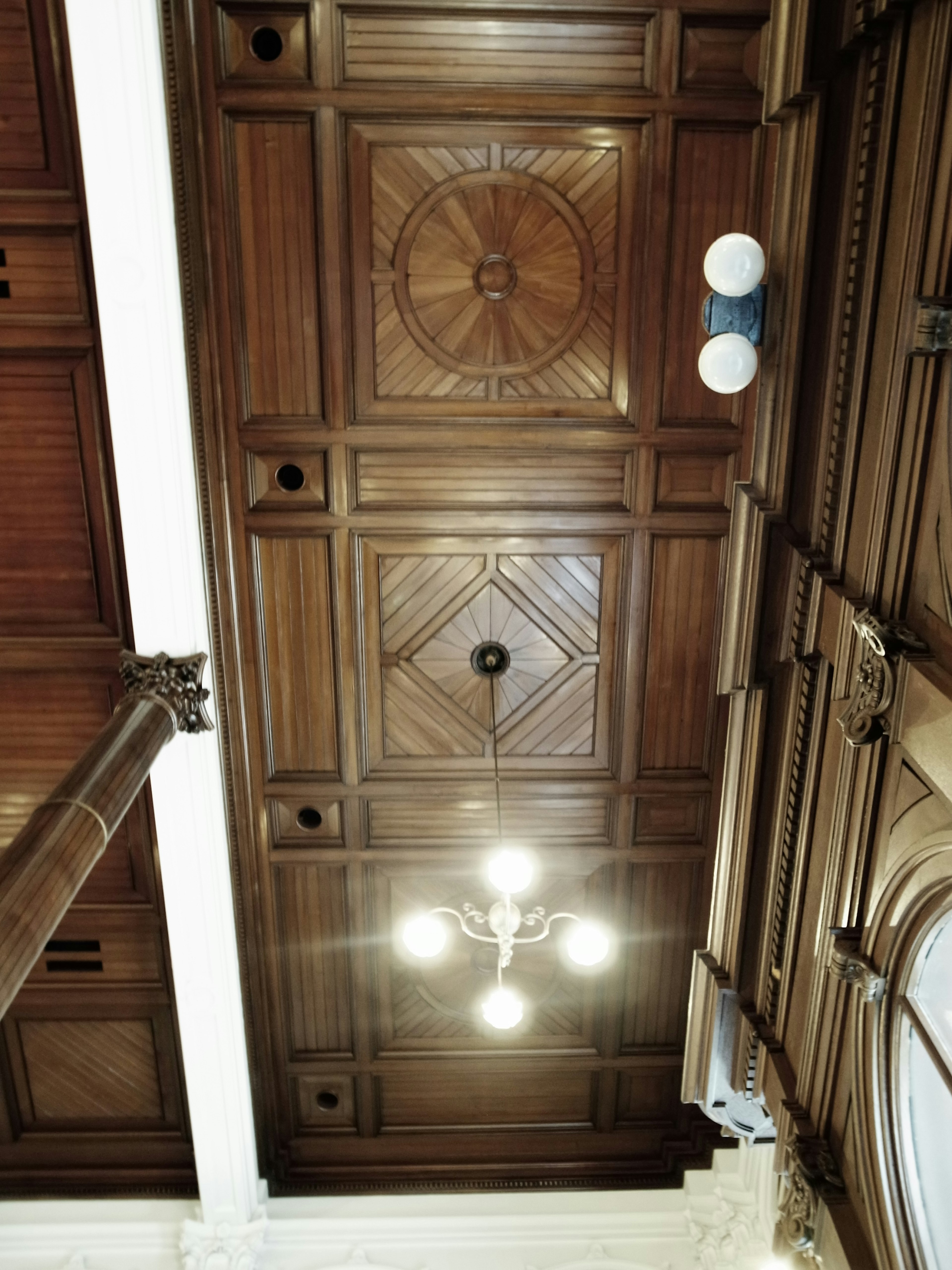 Plafond en bois complexe avec des motifs décoratifs et des luminaires