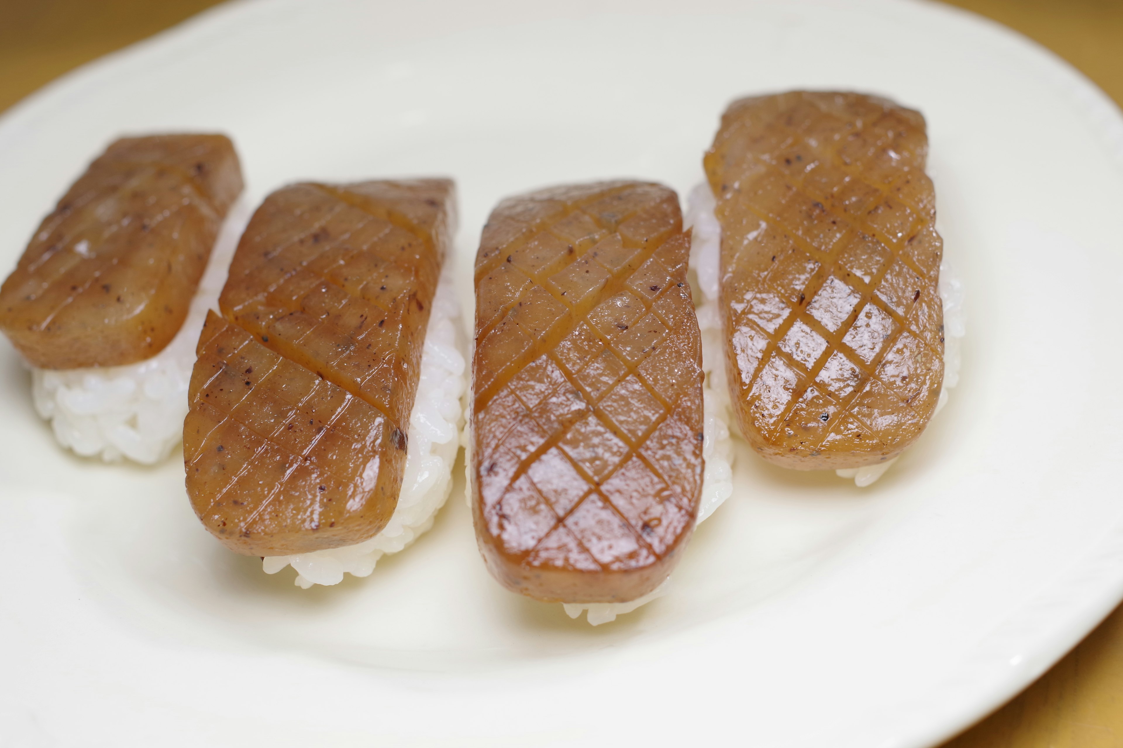 白ご飯の上に置かれた焼き目のあるハムのスライスが並んでいる