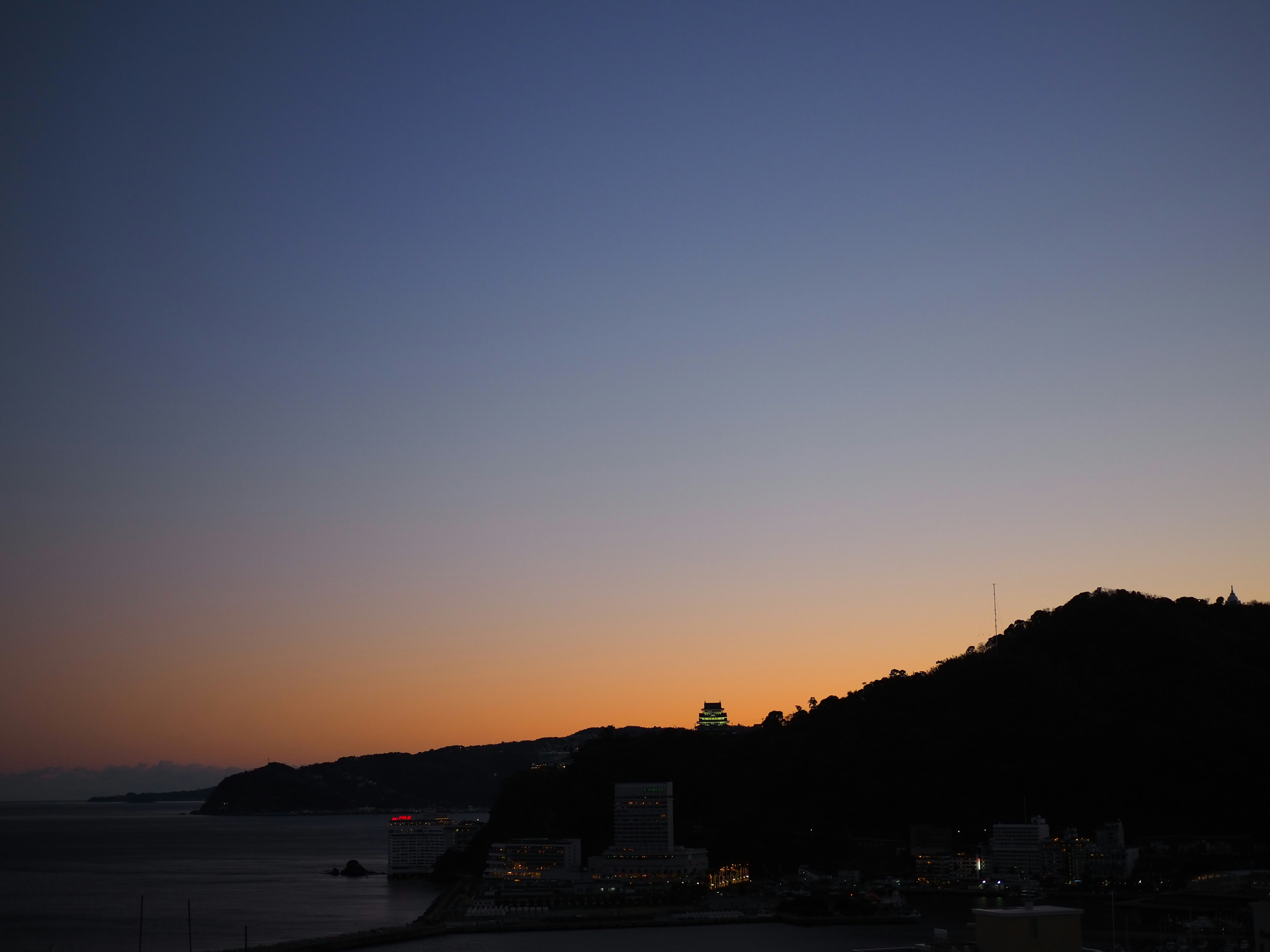 Silhouette costiera al crepuscolo con colori del cielo sfumati