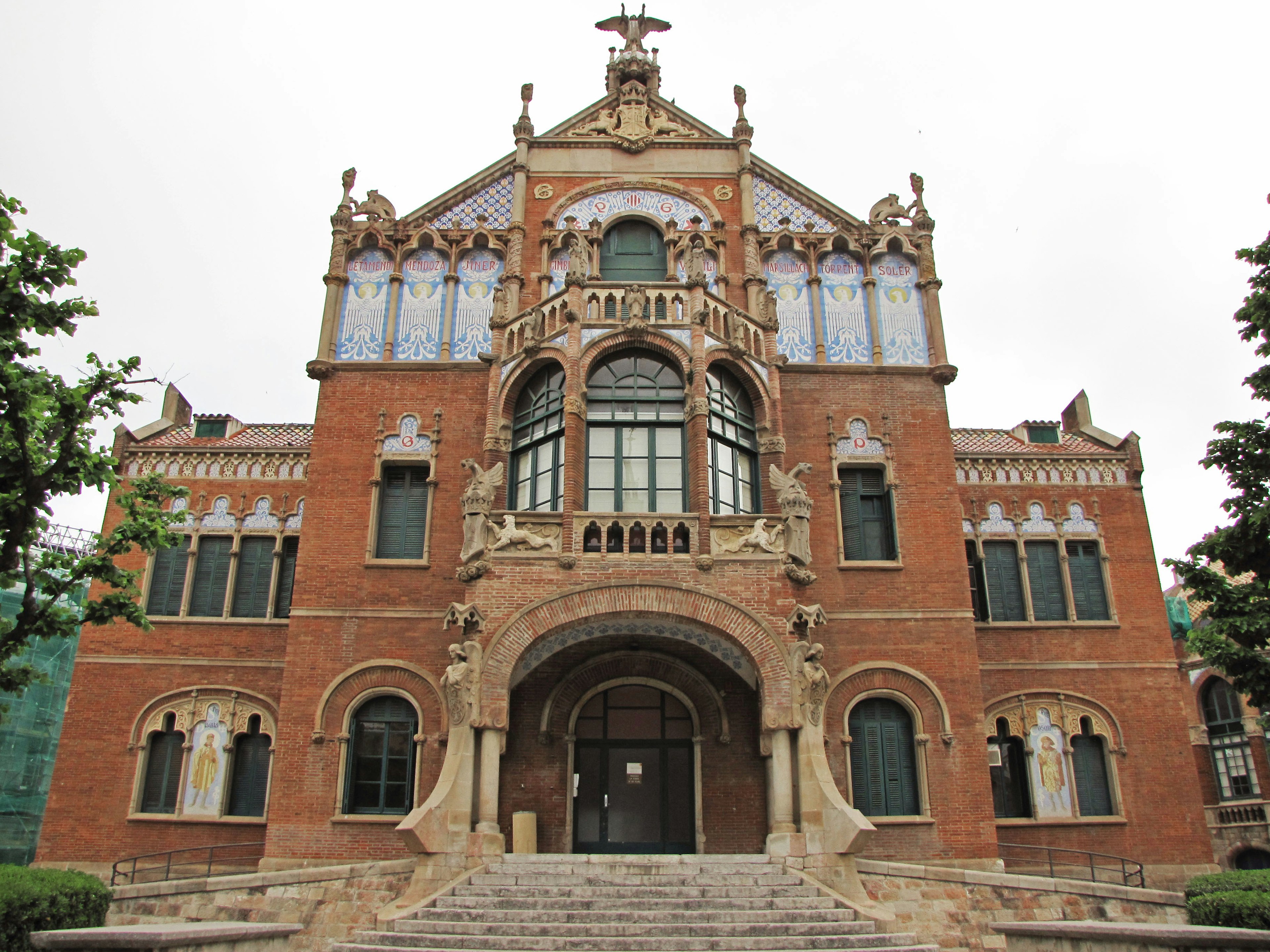 A distinctive red brick building with large windows and decorative facade