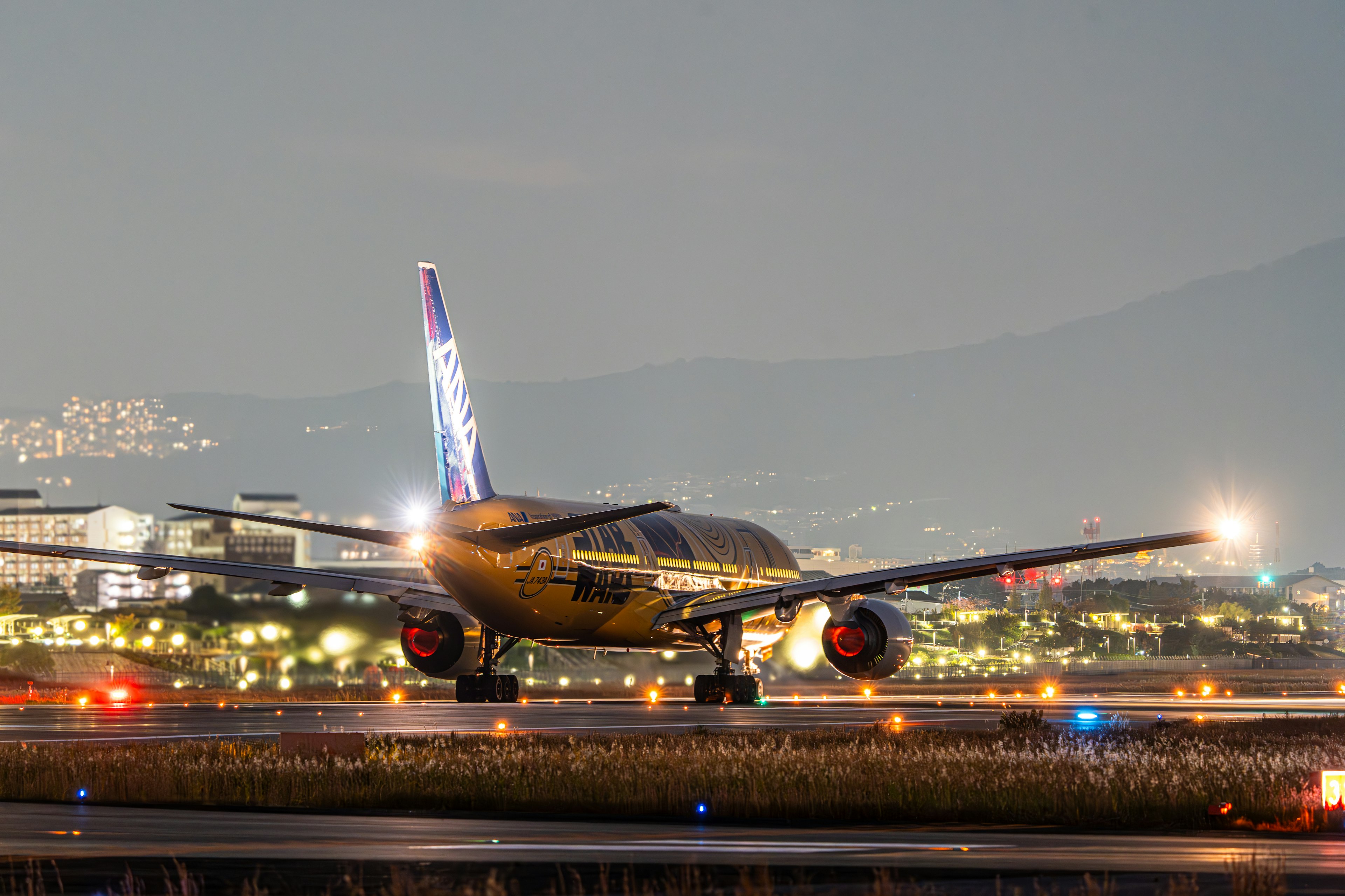 夜の空港で滑走路を走る航空機の写真