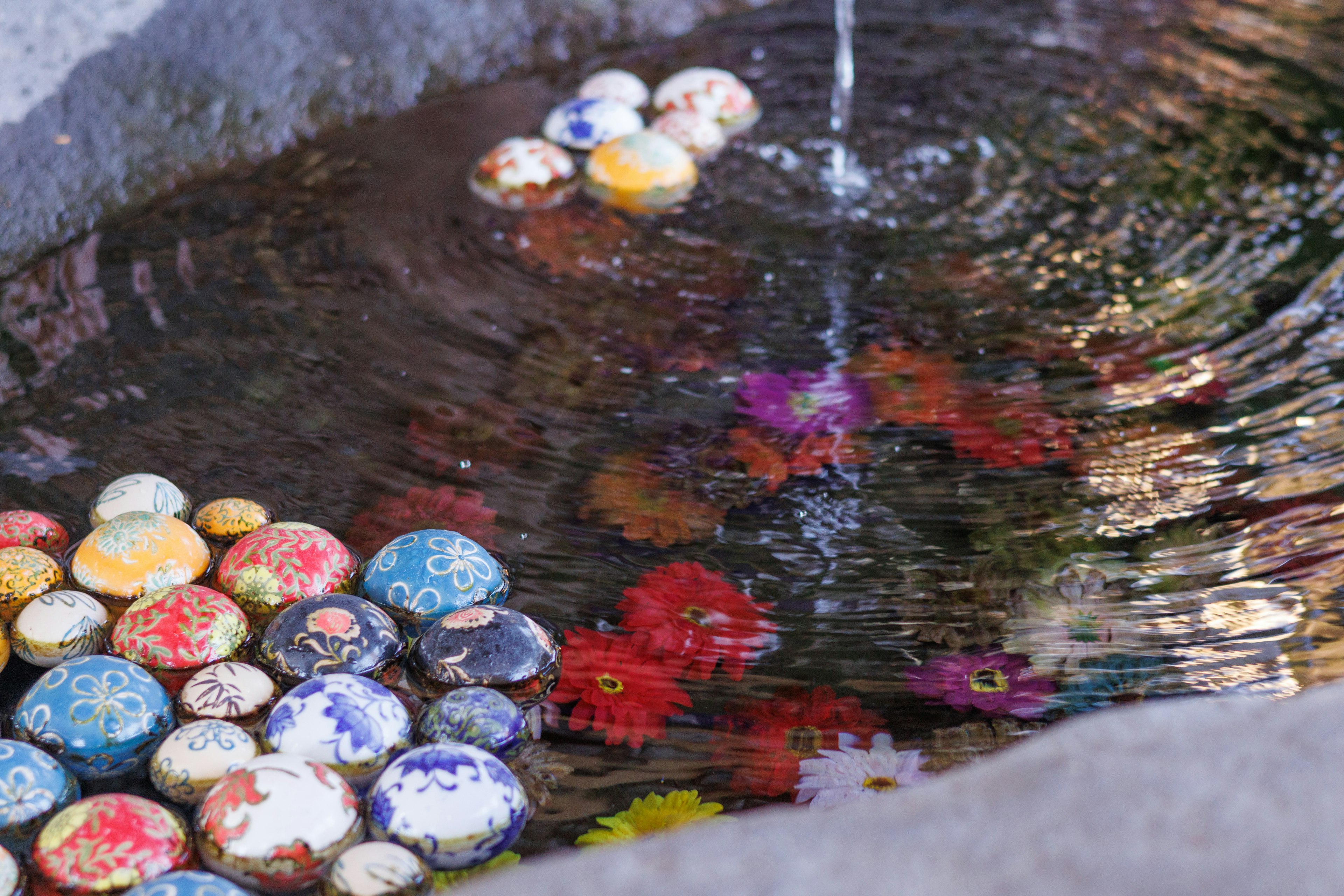 Boules décoratives colorées et motifs floraux flottant à la surface de l'eau