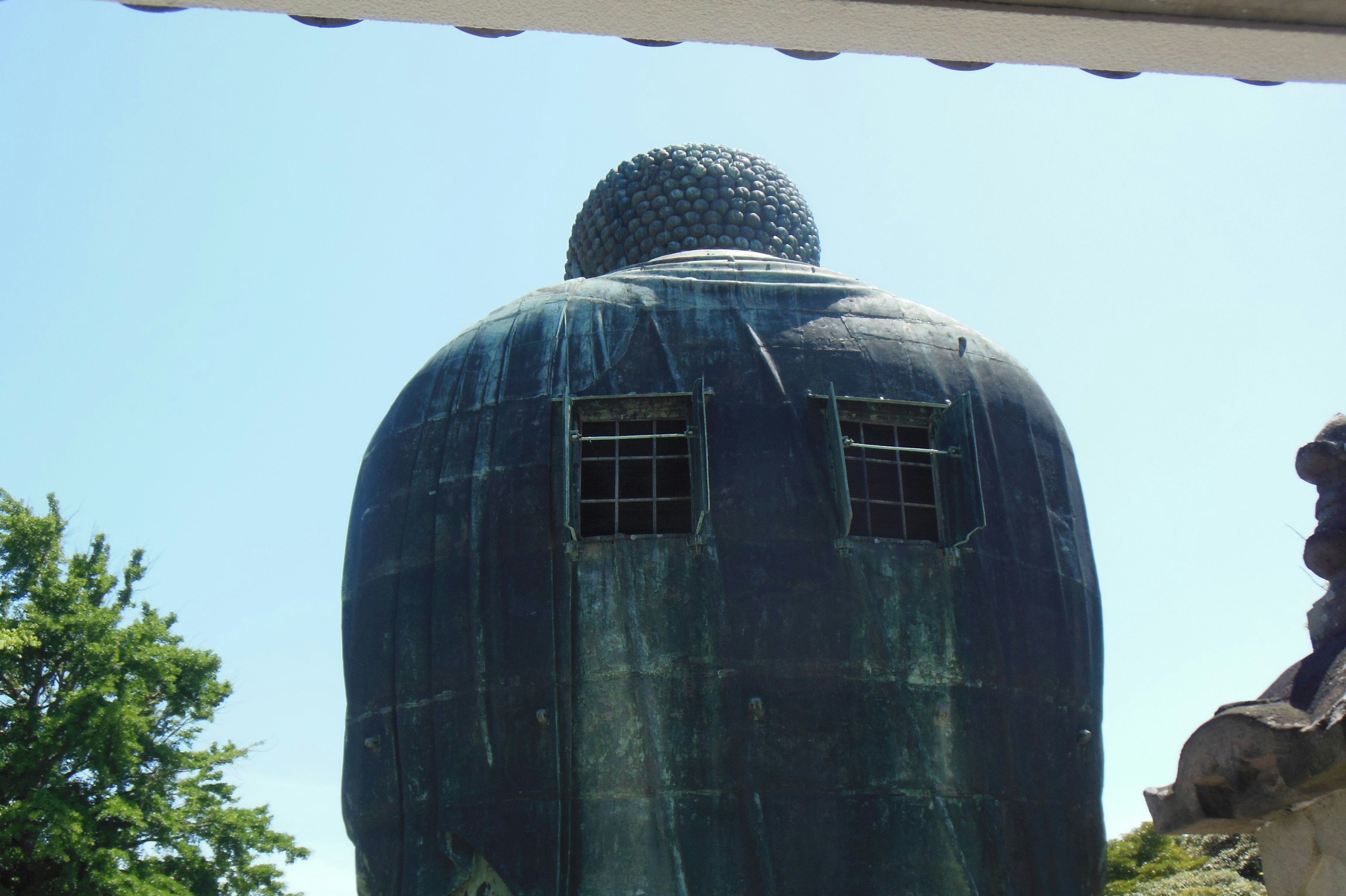 Pemandangan belakang patung Buddha besar di bawah langit biru