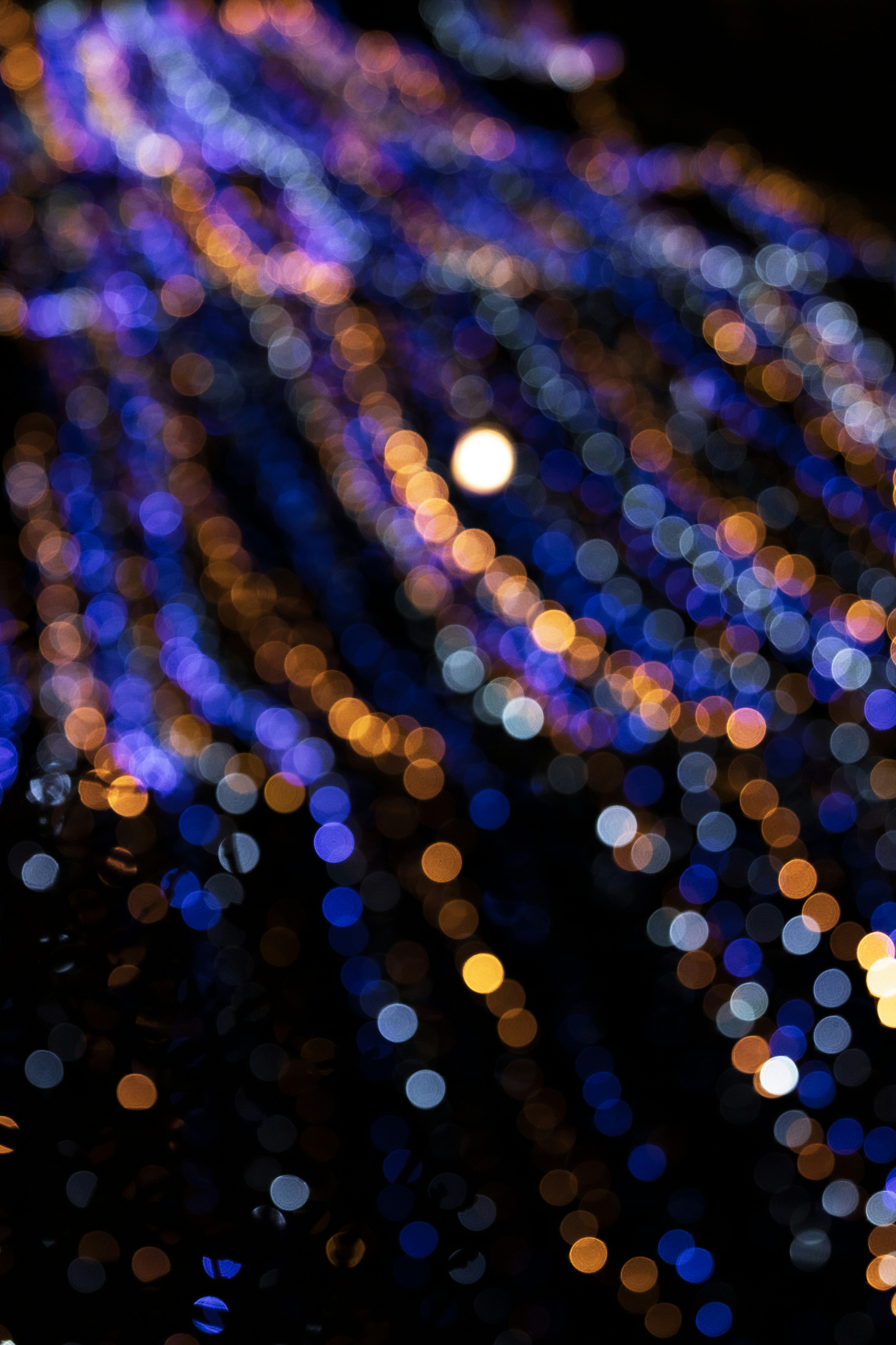 Strisce sfocate di luci blu e arancioni che creano un effetto bokeh