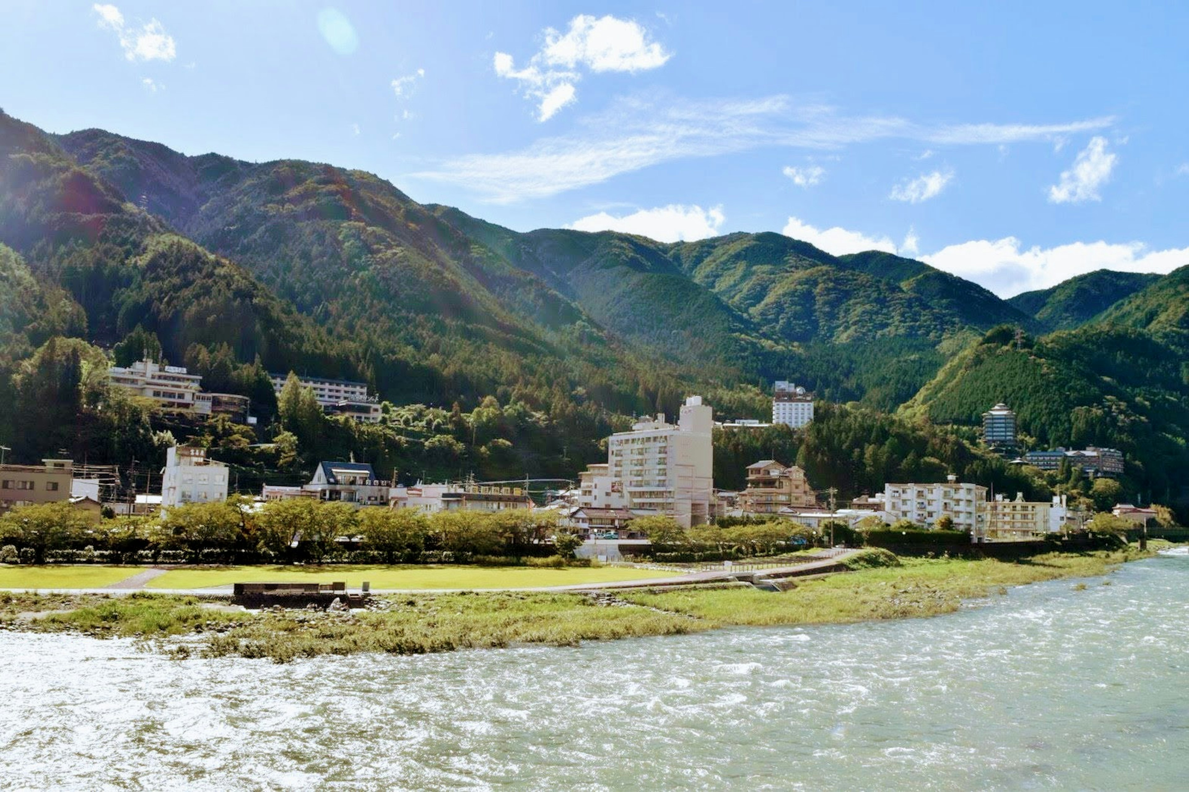 Malerscher Blick auf eine Kurstadt entlang eines Flusses, umgeben von Bergen