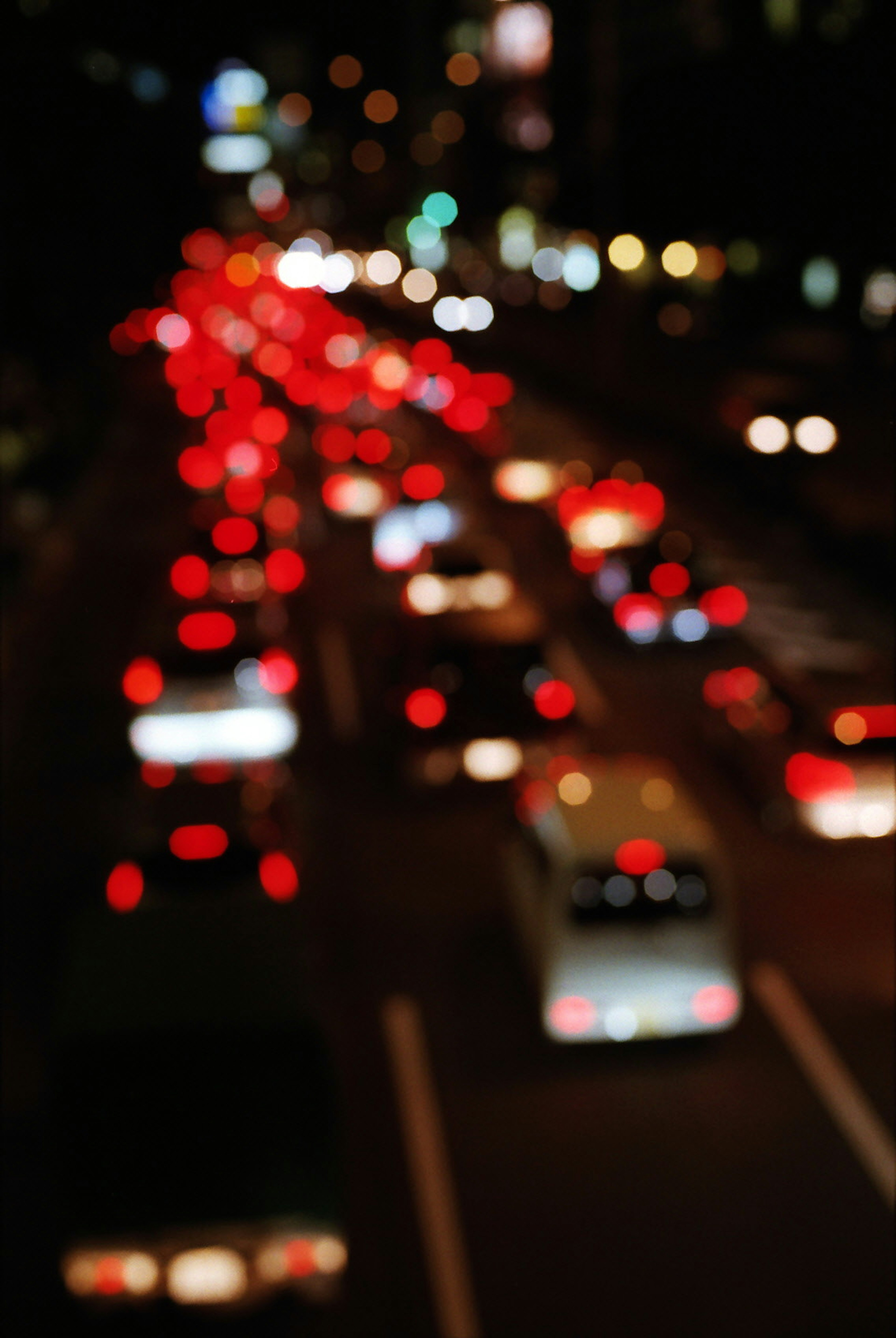 Vista sfocata del traffico notturno con luci rosse e bianche