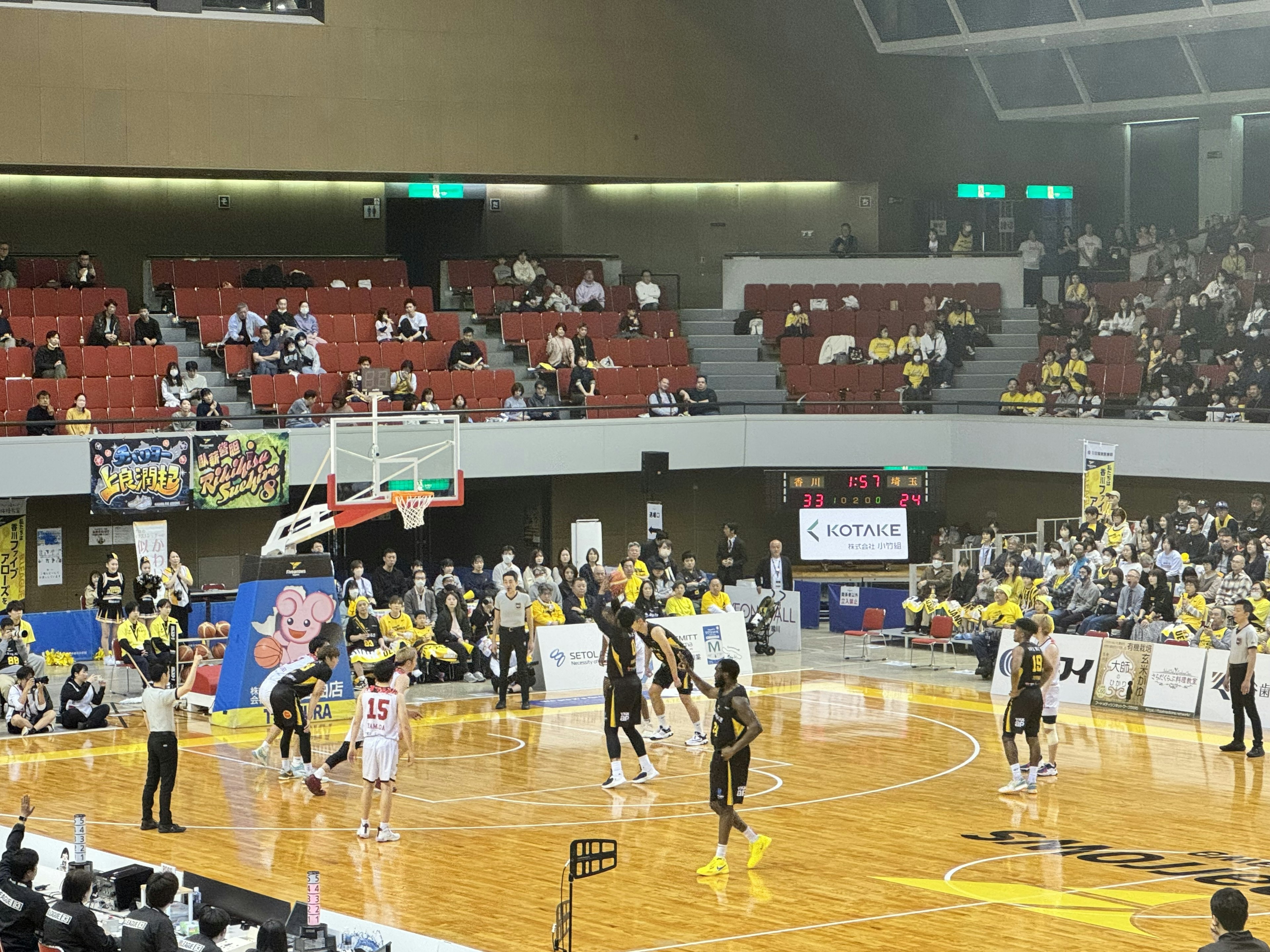 Indoor basketball game featuring players and spectators