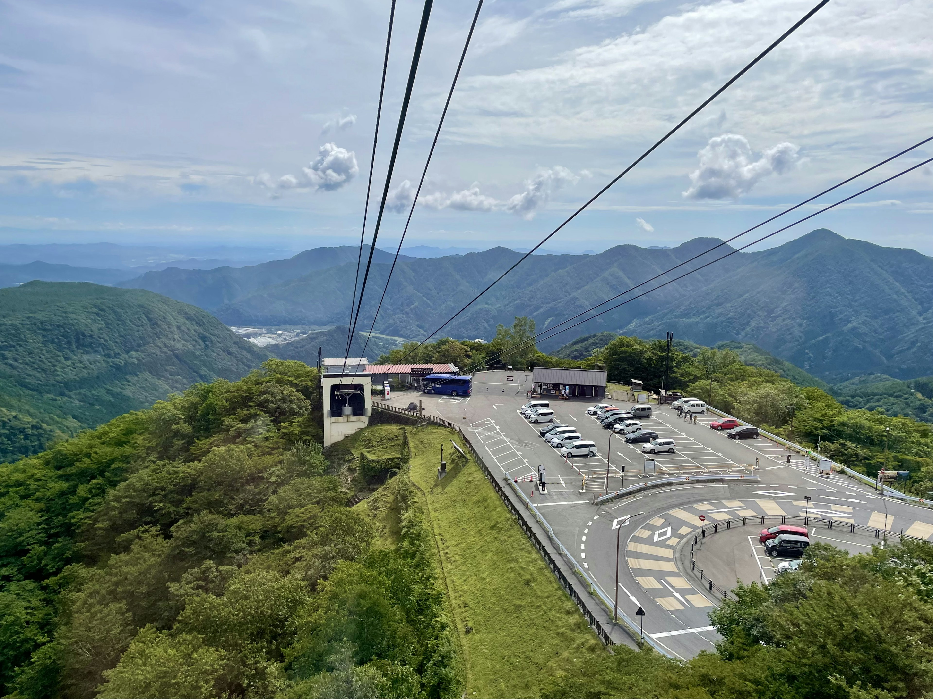 山の上から見たロープウェイの駅と駐車場の風景