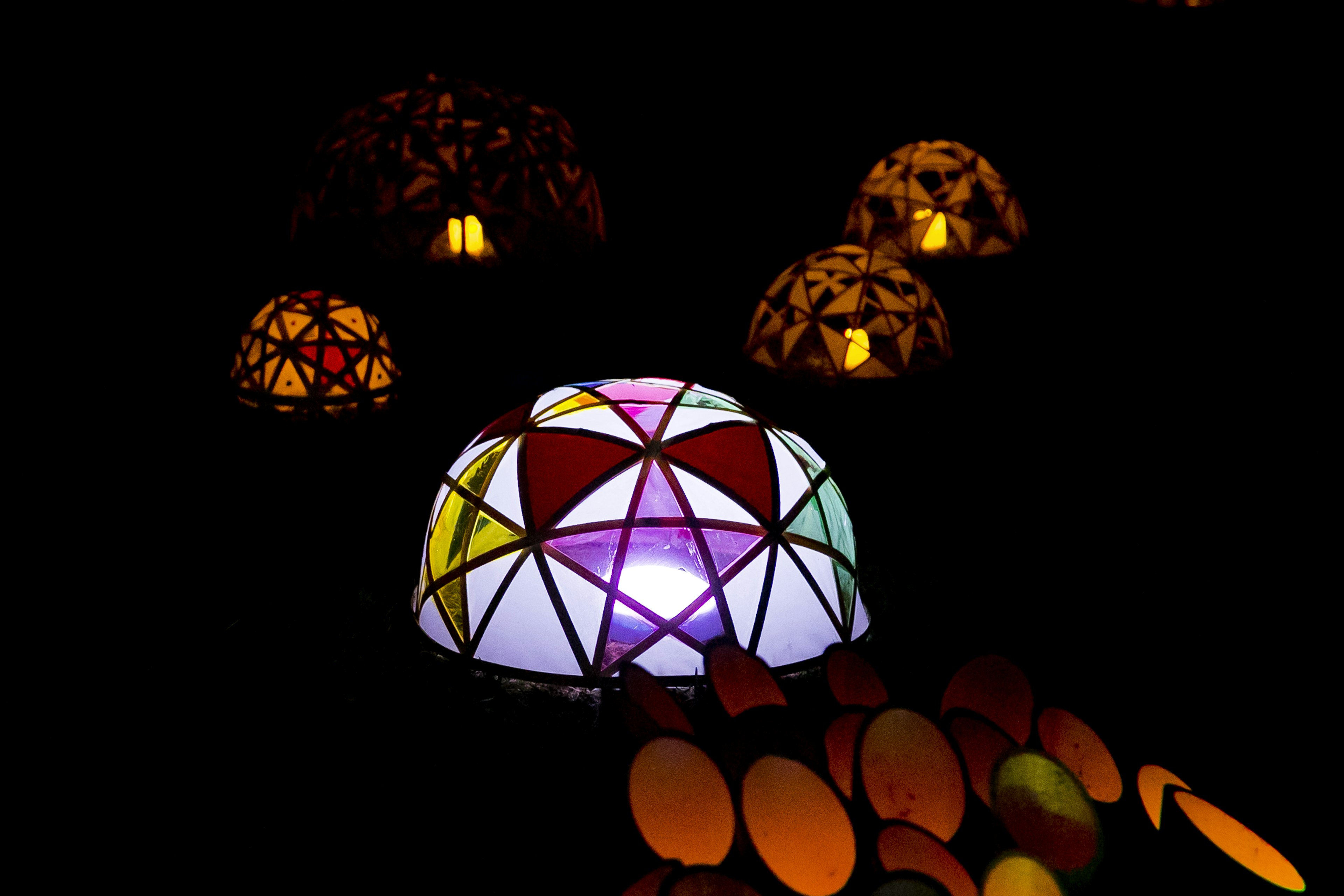 Colorful lamps glowing in the dark with geometric patterns