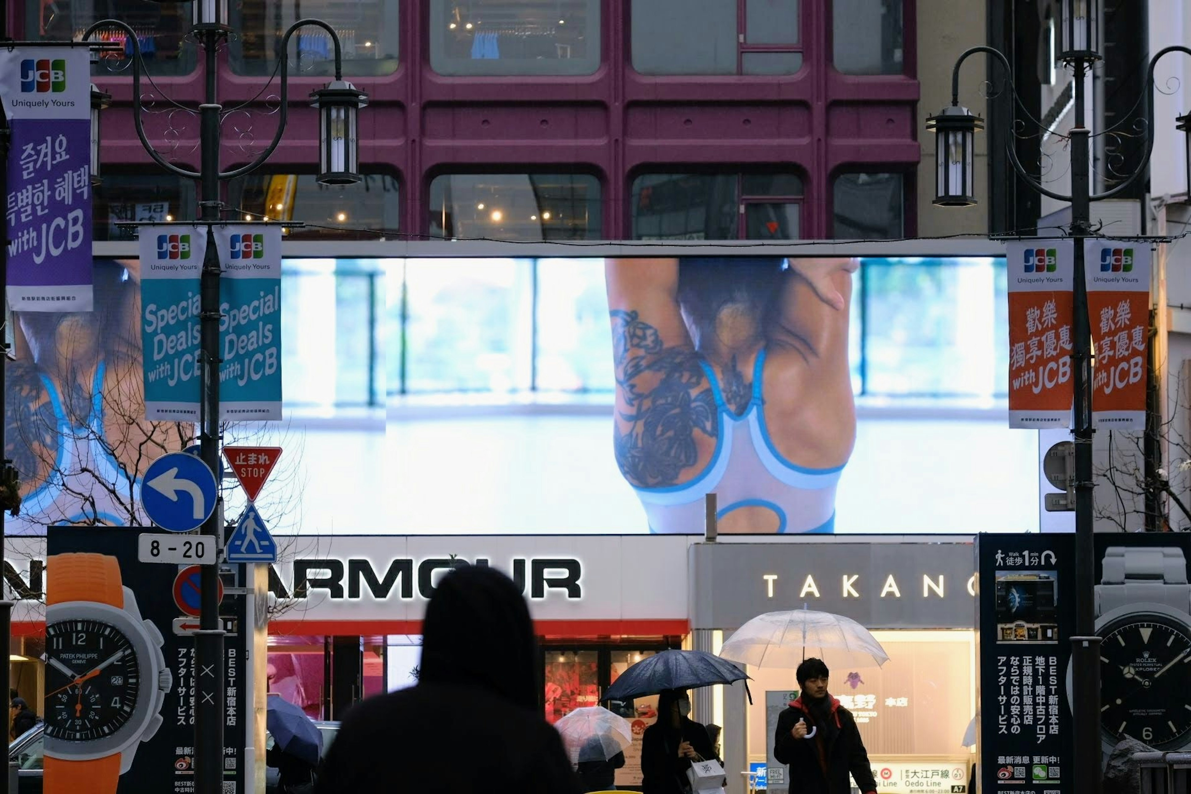 Große digitale Werbung, die eine Frau in einem blauen Outfit in einer belebten Straße zeigt