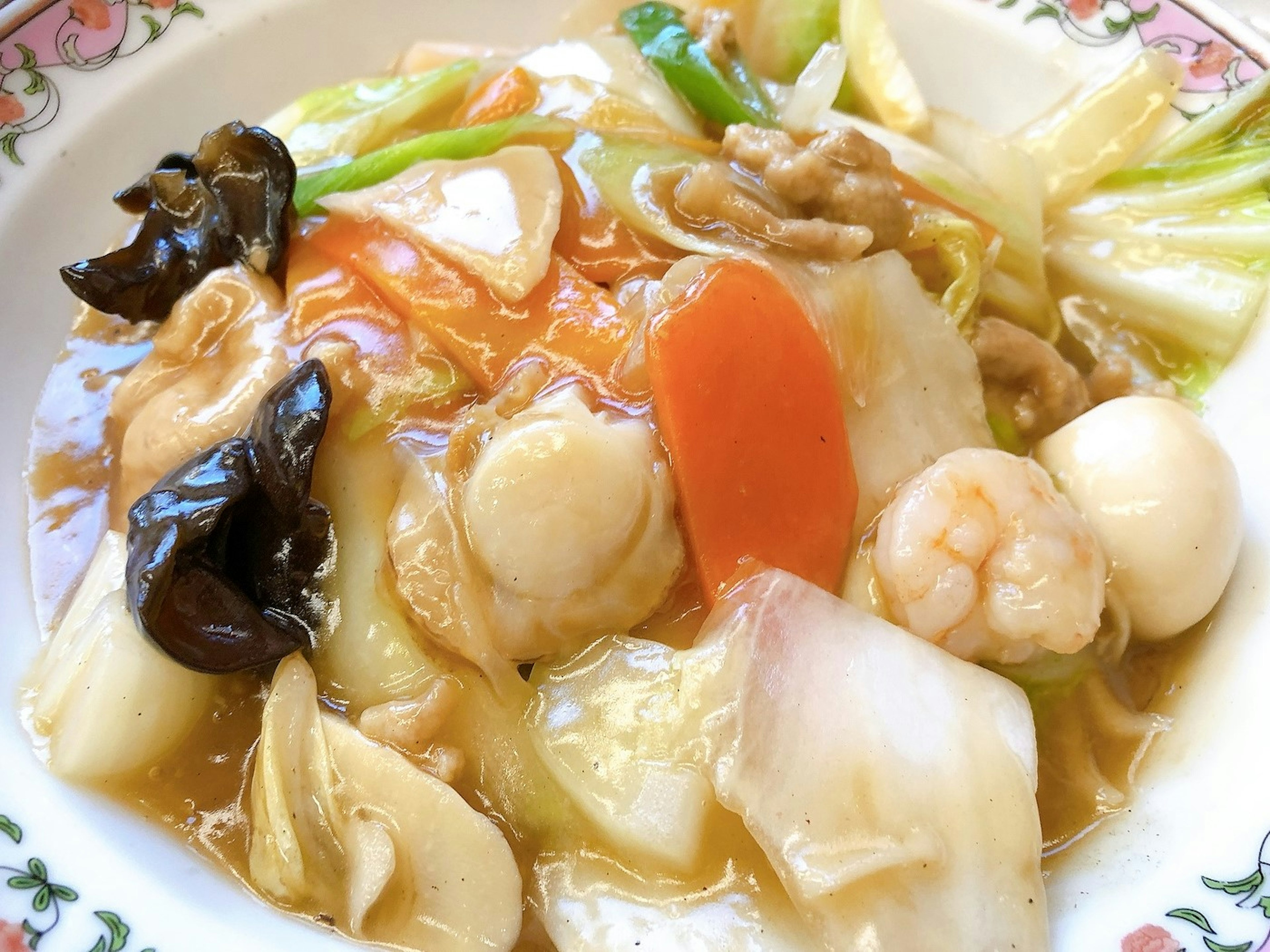 Un plato de cocina china con verduras coloridas y mariscos